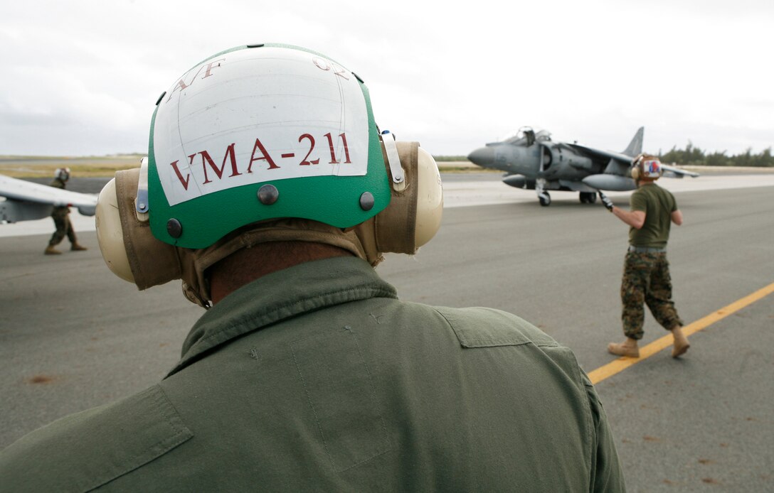 Staff Sgt. Rogelio Gomez, airframes maintenance chief with Marine Attack Squadron 211, observes one of eight AV-8B Harrier jets taxi after landing on Wake Island Jan. 8, 2009. The return of VMA-211 to the remote Pacific atoll marks the first time since May 1993 the squadron, nicknamed the "Wake Island Avengers," has returned to its symbolic birthplace where a handful of the unit's Marines helped defend the island from an overwhelming Japanese invasion force from December 8-23 in 1941 before it was captured. The squadron departed Jan. 10 and flew to Iwakuni, Japan, where it attached to the 31st Marine Expeditionary Unit for a seven- to nine-month deployment. VMA-211 is based in Yuma, Ariz. (Photo by Gunnery Sgt. Bill Lisbon)
