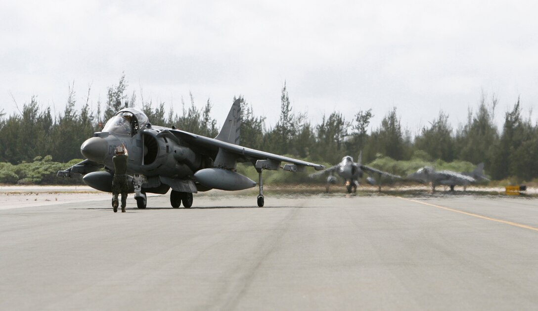 Lance Cpl William W. Holly, a plane captain with Marine Attack Squadron 211, signals to the squadron's commanding officer, Lt. Col. Vance L. Cryer, as he taxis his Harrier jet after landing on Wake Island Jan. 8, 2009. The return of VMA-211 to the remote Pacific atoll marks the first time since May 1993 the bulk of the squadron, nicknamed the "Wake Island Avengers," has returned to its symbolic birthplace where a handful of the unit's Marines helped defend the island from an overwhelming Japanese invasion force from Dec. 8-23, 1941, before its surrender. The squadron flew to Iwakuni, Japan, two days later and attached to the 31st Marine Expeditionary Unit for a seven- to nine-month deployment. VMA-211 is based in Yuma, Ariz. (Photo by Gunnery Sgt. Bill Lisbon)