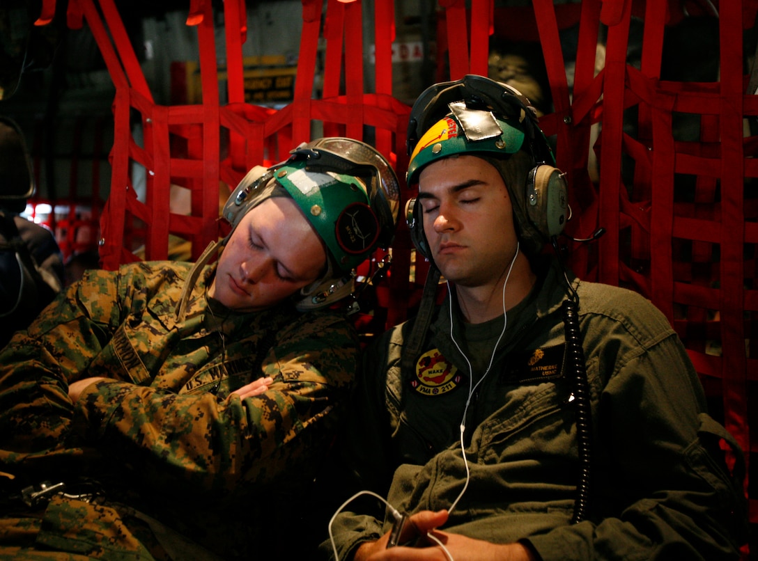 Lance Cpl. Charles L. Harmon and Cpl. Michael P. Matherne, avionics technicians with Marine Attack Squadron 211, sleep during their flight from Hawaii to Wake Island in a KC-130 cargo plane Jan. 7, 2009.  Both Marines were members of an advance maintenance crew tasked to prepare for Harrier landings at stops en route to Iwakuni, Japan, where the squadron recently deployed to for a tour with the 31st Marine Expeditionary Unit. The squadron's return to Wake Island marks the first time since May 1993 the bulk of the squadron has returned to its symbolic birthplace. From Dec. 8-23, 1941, a handful of the unit's Marines helped to defend the island from an overwhelming Japanese invasion force even after most of their planes were destroyed. VMA-211 is based in Yuma, Ariz. (Photo by Gunnery Sgt. Bill Lisbon)