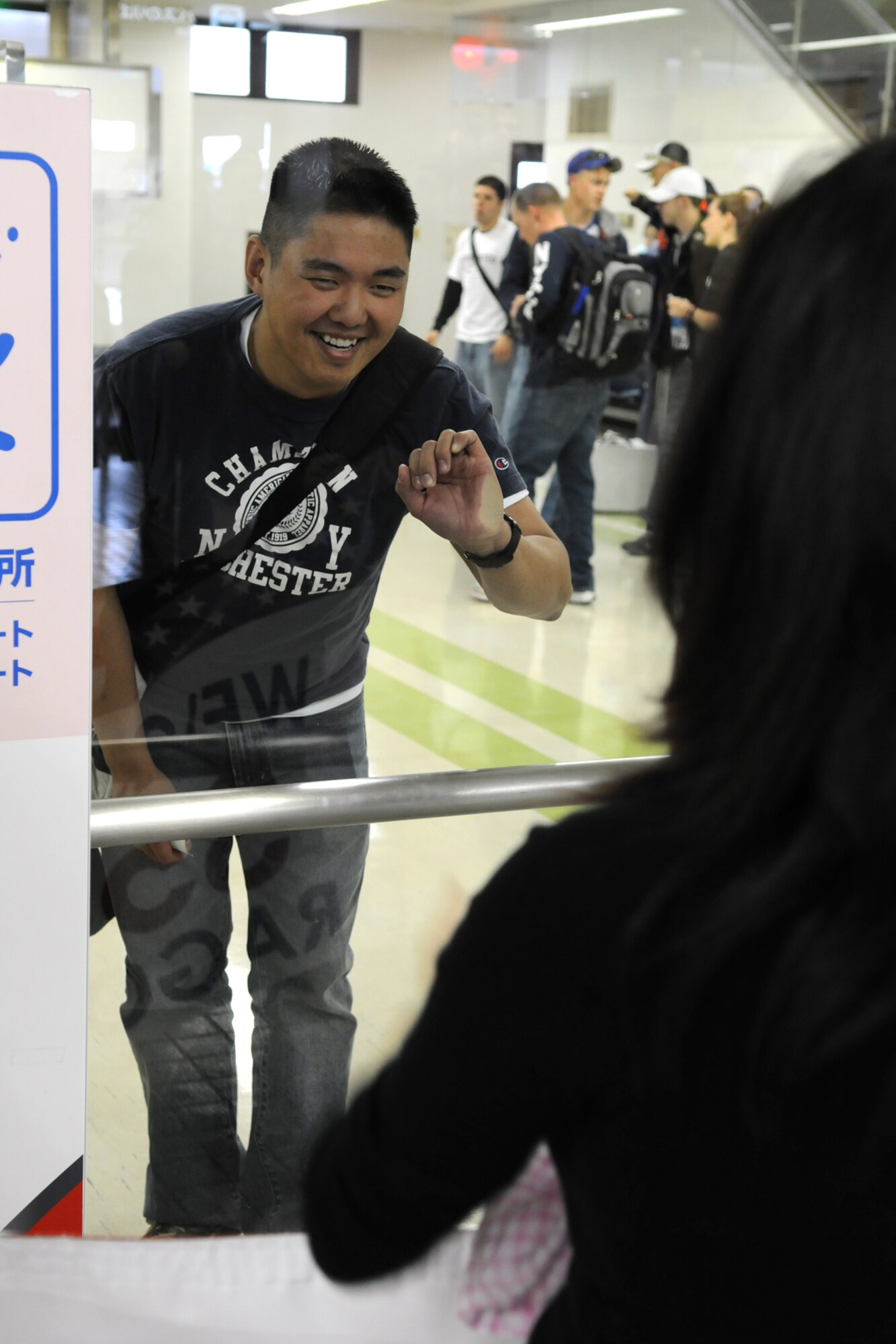 MISAWA CITY, Japan -- Capt. Chin Hsu, 35th Civil Engineer Squadron, waves to his wife and daughter while waiting for luggage at the Misawa City airport Jan. 07, 2009. Captain Hsu returned from a six-month deployment to Balad Air Base, Iraq, where he served as project manager for the 332nd Expeditionary Civil Engineer Squadron. (U.S. Air Force photo by Senior Airman Jamal D. Sutter)