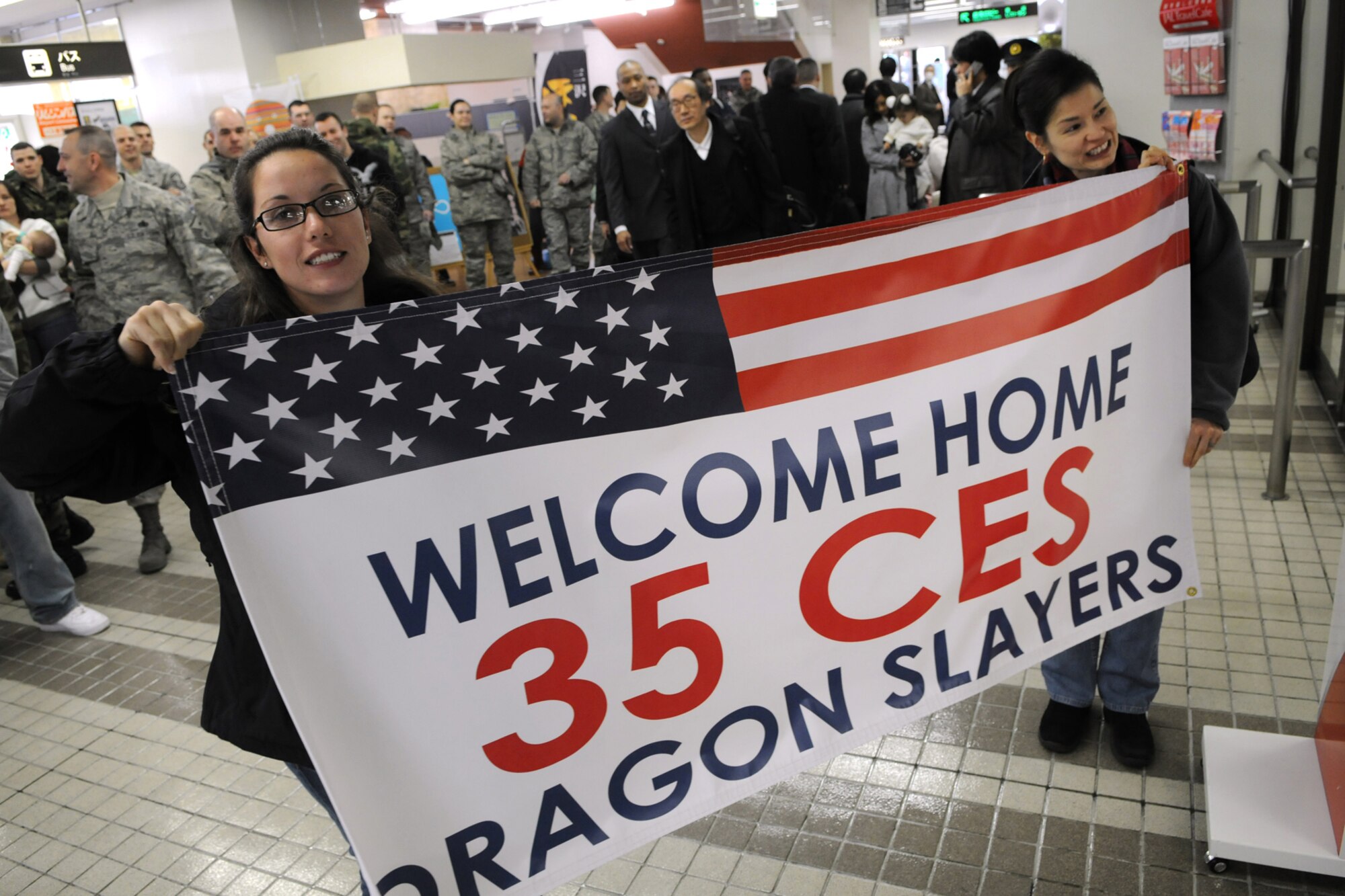 MISAWA CITY, Japan -- Cristine Felty and Jordan Chirline, both representing 35th Civil Engineer Squadron, welcome home nine 35 CES personnel who returned from a deployment to Balad Air Base, Iraq, Jan. 07, 2009. (U.S. Air Force photo by Senior Airman Jamal D. Sutter) 