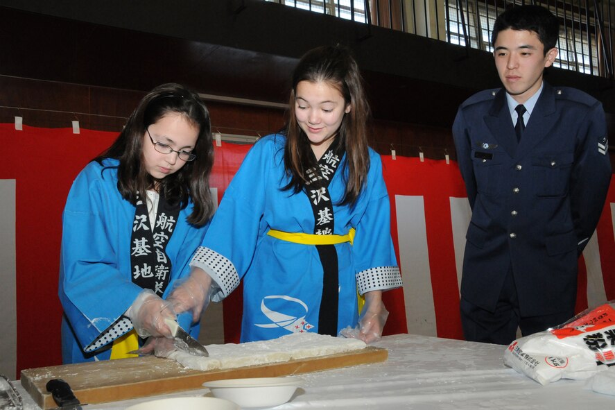 MISAWA AIR BASE, Japan -- Maddy and Alex, daughters of Col. Mark Altobelli, 35th Operations Group commander, participate in the annual rice pounding ceremony at the Japan Air Self-Defense Force gymnasium Dec. 17, 2008. The ceremony gave the girls a chance to learn more about the Japanese culture and native traditions. (U.S. Air Force photo by Senior Airman Jamal D. Sutter)