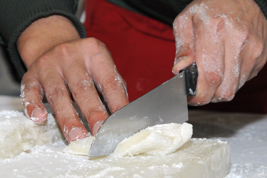 MISAWA AIR BASE, Japan -- "Mochi," or rice cake, is cut during the annual rice pounding ceremony at the Japan Air Self-Defense Force gymnasium Dec. 17, 2008. The rice cake is made by pounding steamed glutinous rice in a large wooden mortar with a large wooden mallet. (U.S. Air Force photo by Senior Airman Jamal D. Sutter)