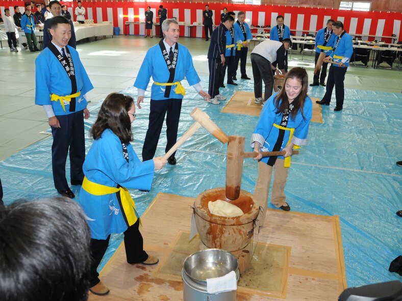 MISAWA AIR BASE, Japan -- Maddy and Alex, daughters of Col. Mark Altobelli, 35th Operations Group commander, participate in the annual rice pounding ceremony at the Japan Air Self-Defense Force gymnasium Dec. 17, 2008. Pounding rice is an activity the girls said they never imagined they'd do while living in Japan. (U.S. Air Force photo by Senior Airman Jamal D. Sutter)