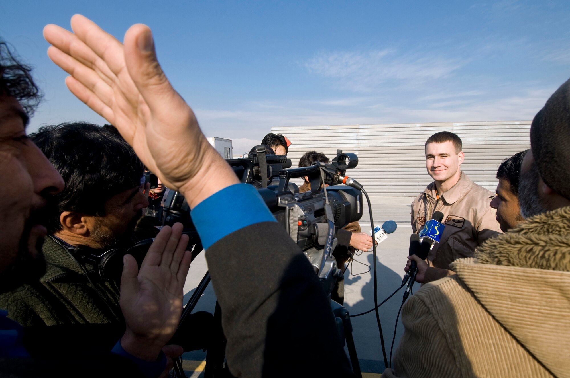 A report from an Afghan television station asks a weapons systems officer a question about the F-15E Strike Eagle capabilities during Afghan Media Day Jan. 5 at Bagram Airfield, Afghanistan. The media day consisted of a tour of fighter aircraft and a close-air support briefing from the wing commander. (U.S. Air Force photo/Staff Sgt. Samuel Morse)

