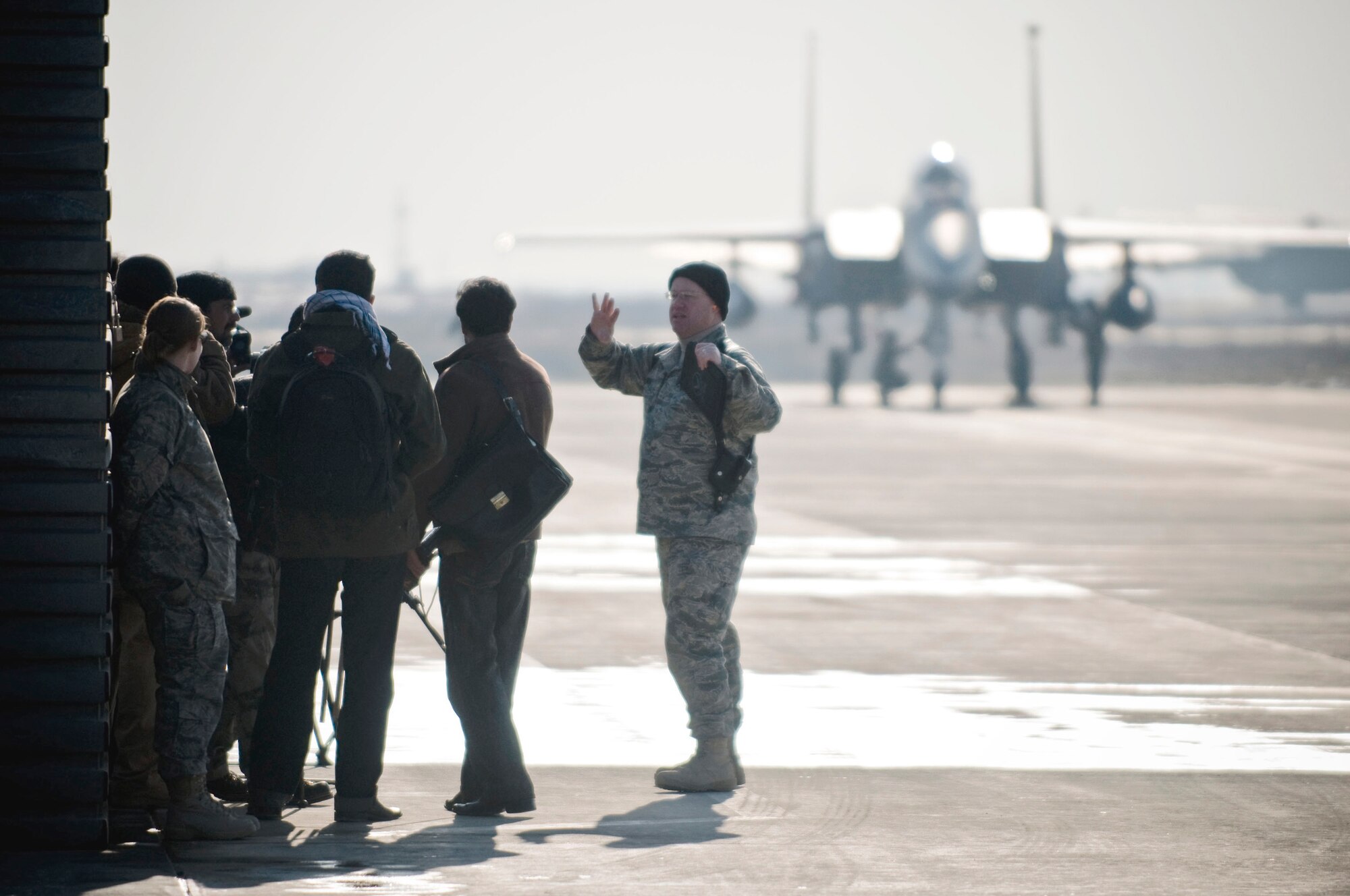 Capt. Tom Wenz briefs Afghan media on close-air support while an F-15E Strike Eagle is disarmed in the background Jan. 5 at Bagram Airfield, Afghanistan. Members of the Afghan media were invited on base to learn about the 455th AEW close-air support mission. Captain Wenz is a 455th Air Expeditionary Wing public affairs officer. (U.S. Air Force photo/Staff Sgt. Samuel Morse)
