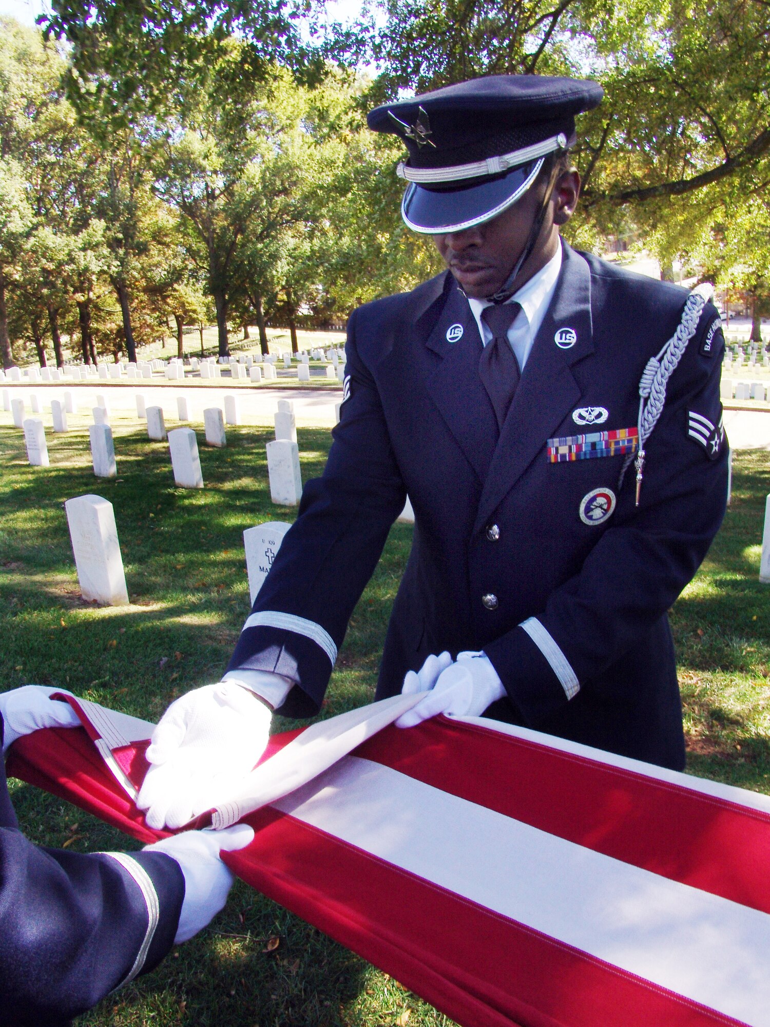 SrA  Brandon Rogers initiates the flag folding sequence for a deceased Air Force military member. U. S. Air Force photo by SSgt. Marcus Zellner  