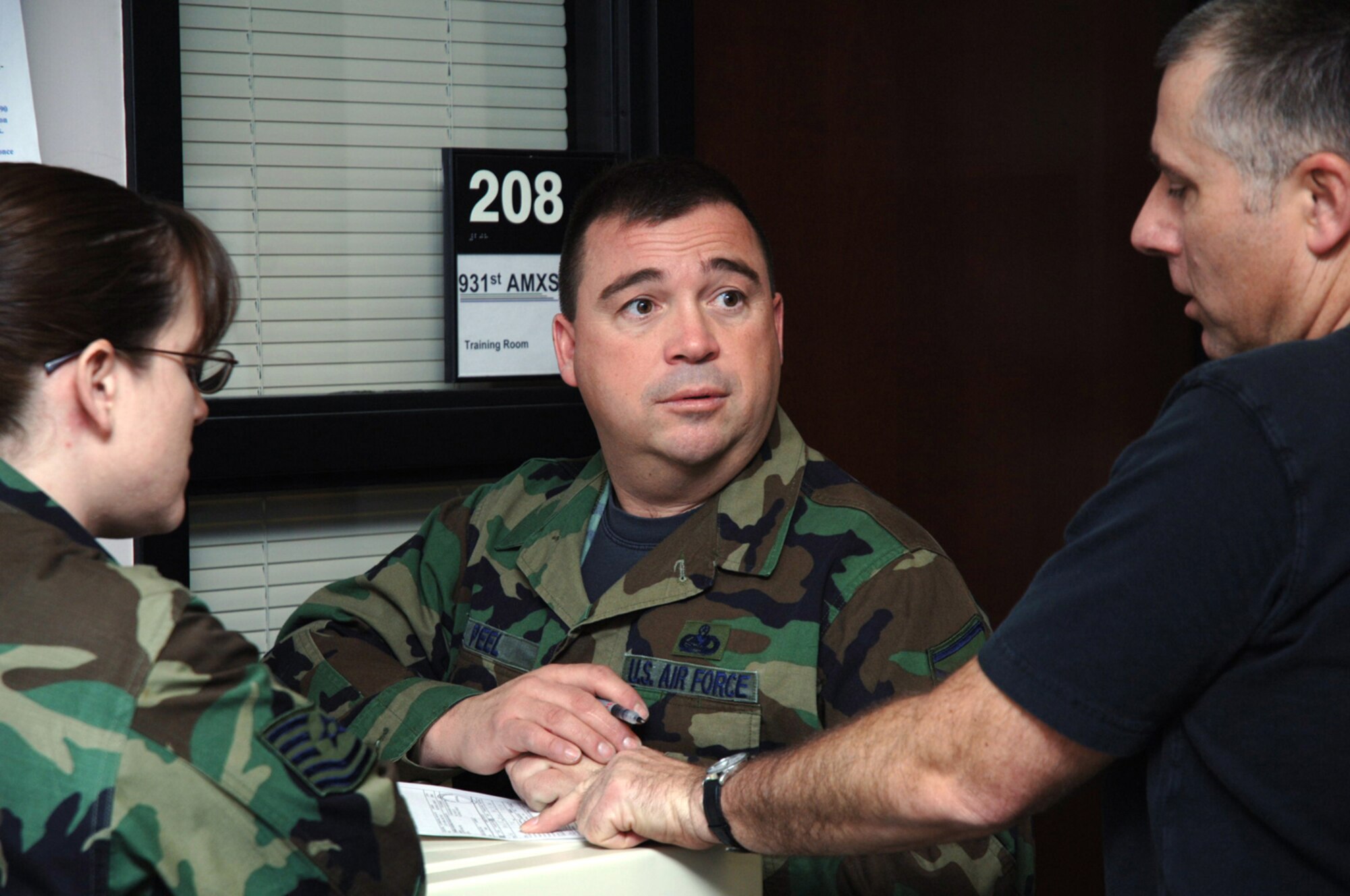 The 931st Aircraft Maintenance Squadron's Master Sgt. Eric Peel (center) and Tech. Sgt. David Sevart discuss some paperwork during the March 2008 Unit Training Assembly just prior to the squadron's annual chili cookoff.  Sergeant Peel's "Tailgate Chili" was  voted the best at the cookoff.  Mary Boulett, wife of the squadron's Senior Master Sgt. John Boulett, earned second place and the squadron's Senior Master Sgt. Ernest Goethe came in third. Sergeant Sevart, cookoff organizer, said the event raised more than $140 for AMXS' retirement fund.