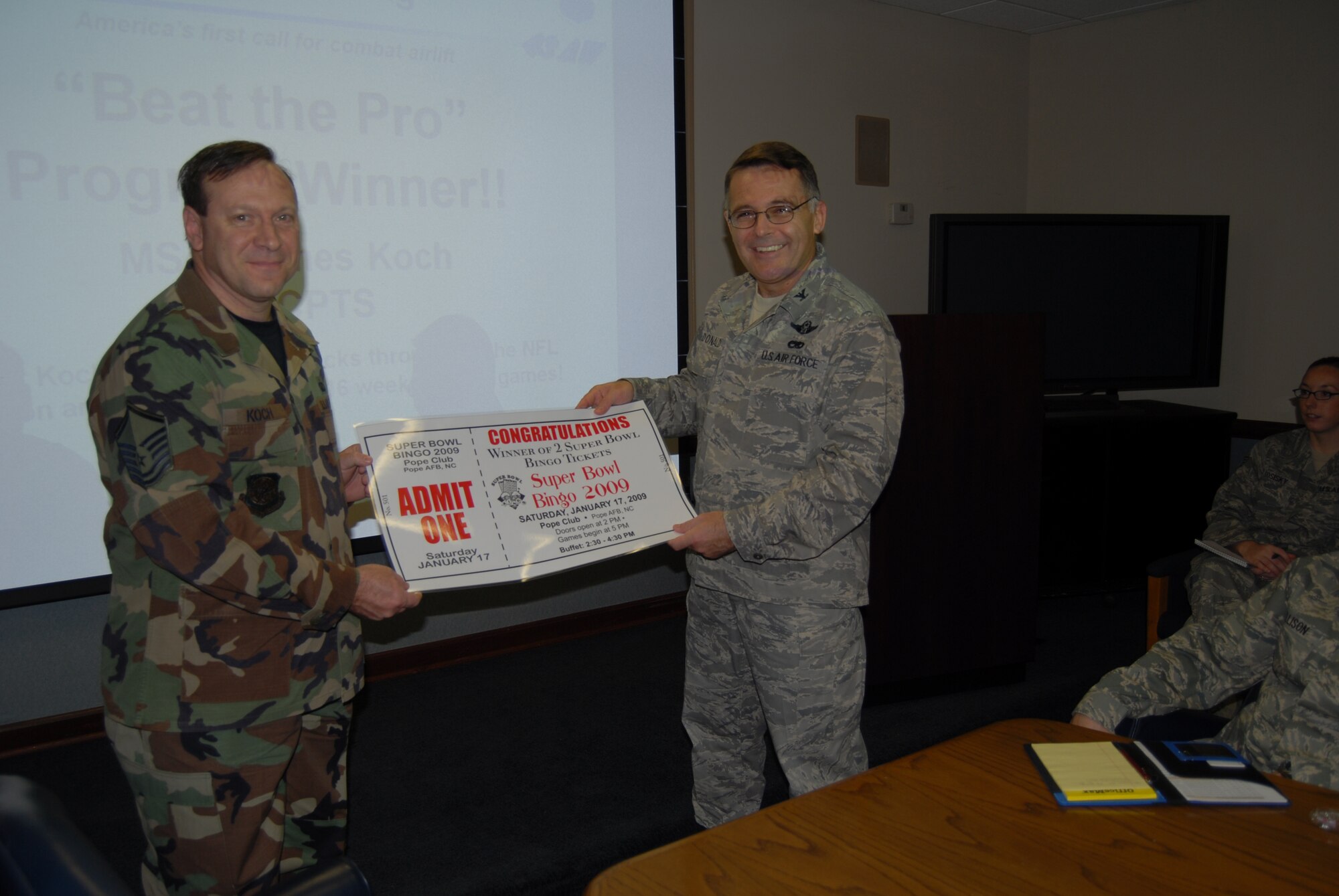 Col. John McDonald, 43rd Airlift Wing Commander, presents Master Sgt. James Koch, 43rd Comptroller Squadron, with two Super Bowl bingo tickets Jan. 6 as reward for winning this year's “Beat the Pro” game. Sergeant Koch played all 17 weeks of the regular National Football League season and matched wits with the wing leadership, he picked a total of 46 correct games out of 84 played and was crowned as this year’s winner. Other winners include, Levon and Brenda Atterberry who tied for 2nd with 45 correct picks, Brandon Johnson and Staff Sgt. Jessica Kosisky tied for 4th with 44 correct picks and Colonel McDonald and Brian Cerney who tied for 6th with 43 correct picks. A special thank you to everyone who participated and to the 43rd Force Support Squadron for their donations of the Super Bowl Bingo prizes and other prizes collected. (U.S. Air Force Photo by Airman 1st Class Mindy Bloem)