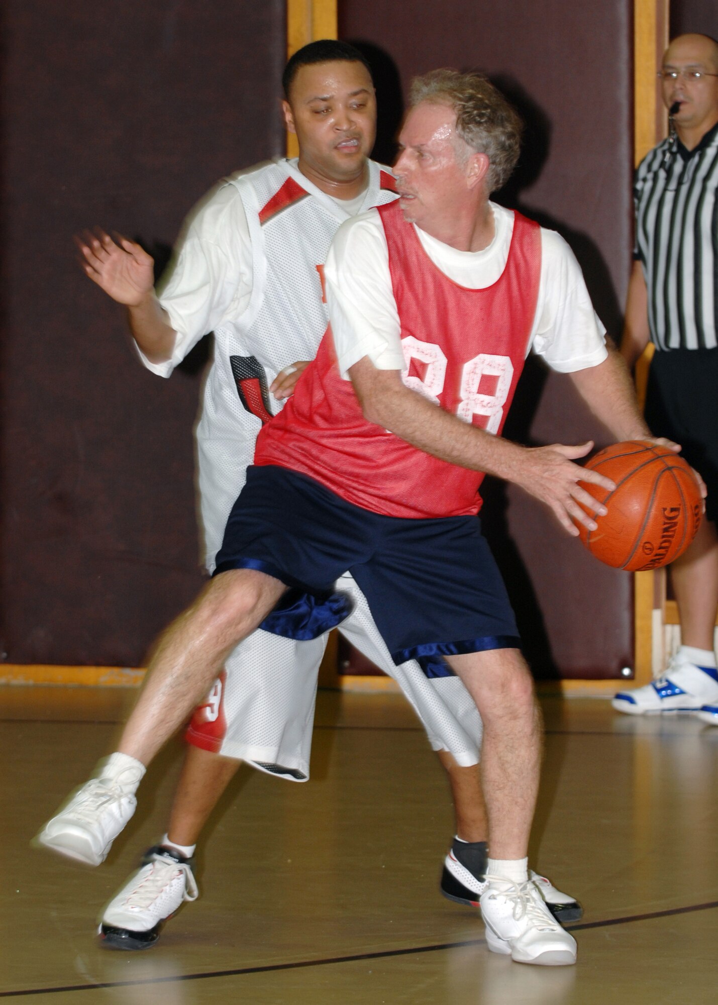 John Drake, Department of Defense Dependant School guard, attempts to pass the ball to a teammate while Lamar Dixon, 39th Logistics Readiness Squadron, trys to cover him. Though a close game, 39 LRS  beat DoDDS 52-50. (Air Force photo by Staff Sgt. Jeff Nevison)
