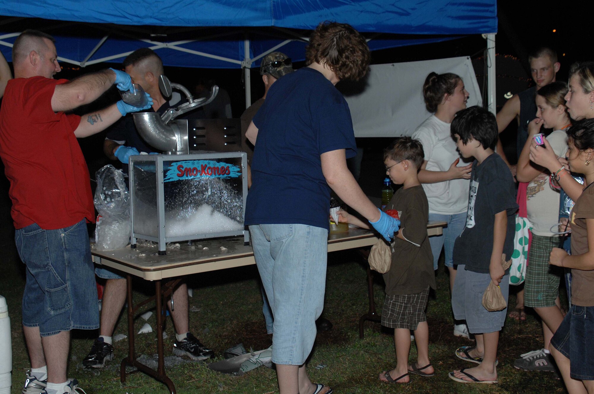 ANDERSEN AIR FORCE BASE, Guam - Airmen from the 36th Medical Group make snowcones for the base community during Rota Walk Dec. 20. Amidst the Christmas lights and decorations along Rota Drive, several toys, candy, and entertainment were available to invoke holiday cheer. (U.S. Air Force photo by Senior Airman Sonya Croston)