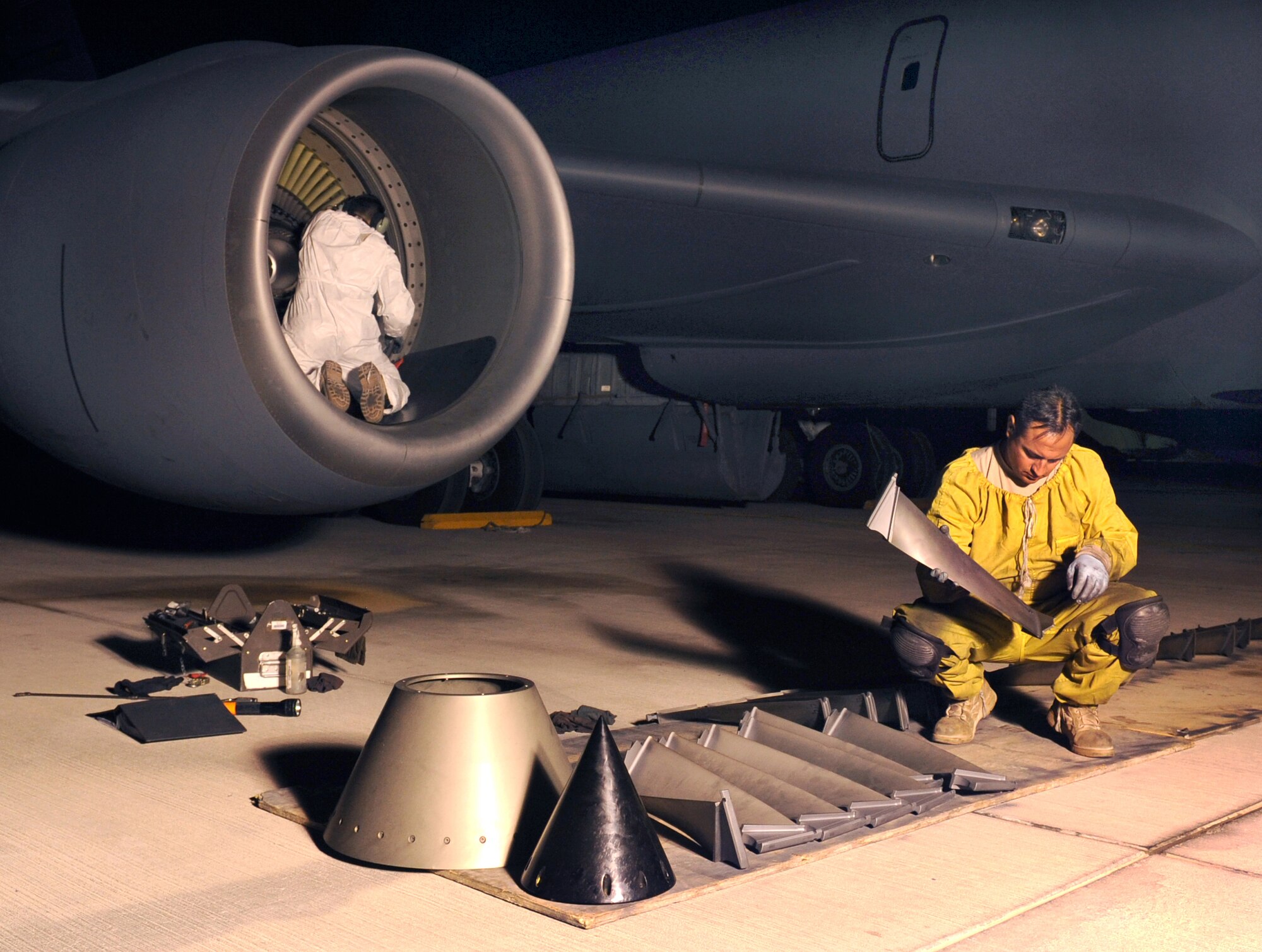 Tech. Sgt. Joseph Vigil performs a final inspection of blades from the fan assembly of a KC-135 Stratotanker engine Jan. 8 at an air base in Southwest Asia prior to handing them to Tech. Sgt. Eric Peterson to place back in the engine.  The fan assembly is inspected every 1,500 hours of engine run time and during the inspection the blades are examined for any defects that would prevent the engine from operating properly.  Both sergeants, assigned to the 379th Expeditionary Aircraft Maintenance Squadron, are deployed from McConnell Air Force Base, Kan.  (U.S. Air Force photo/Staff Sgt. Joshua Garcia)