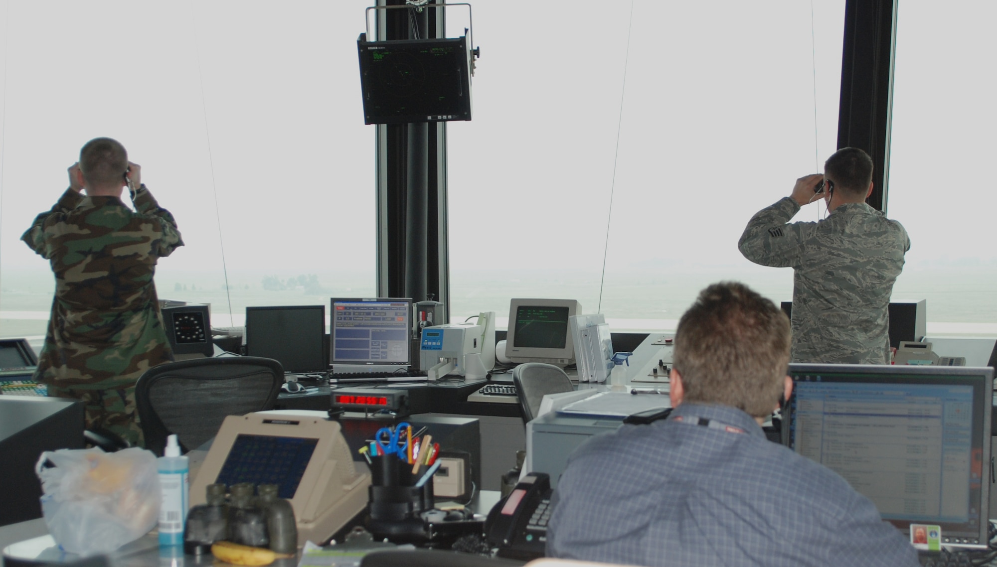 Members of the 9th Operations Support Squadron's air traffic controllers work together Jan. 7 in the control tower as a plane comes in to land. From 11 stories high, the flight tower provides a panoramic view of the airfield. (Photo by Airman 1st Class Chuck Broadway)