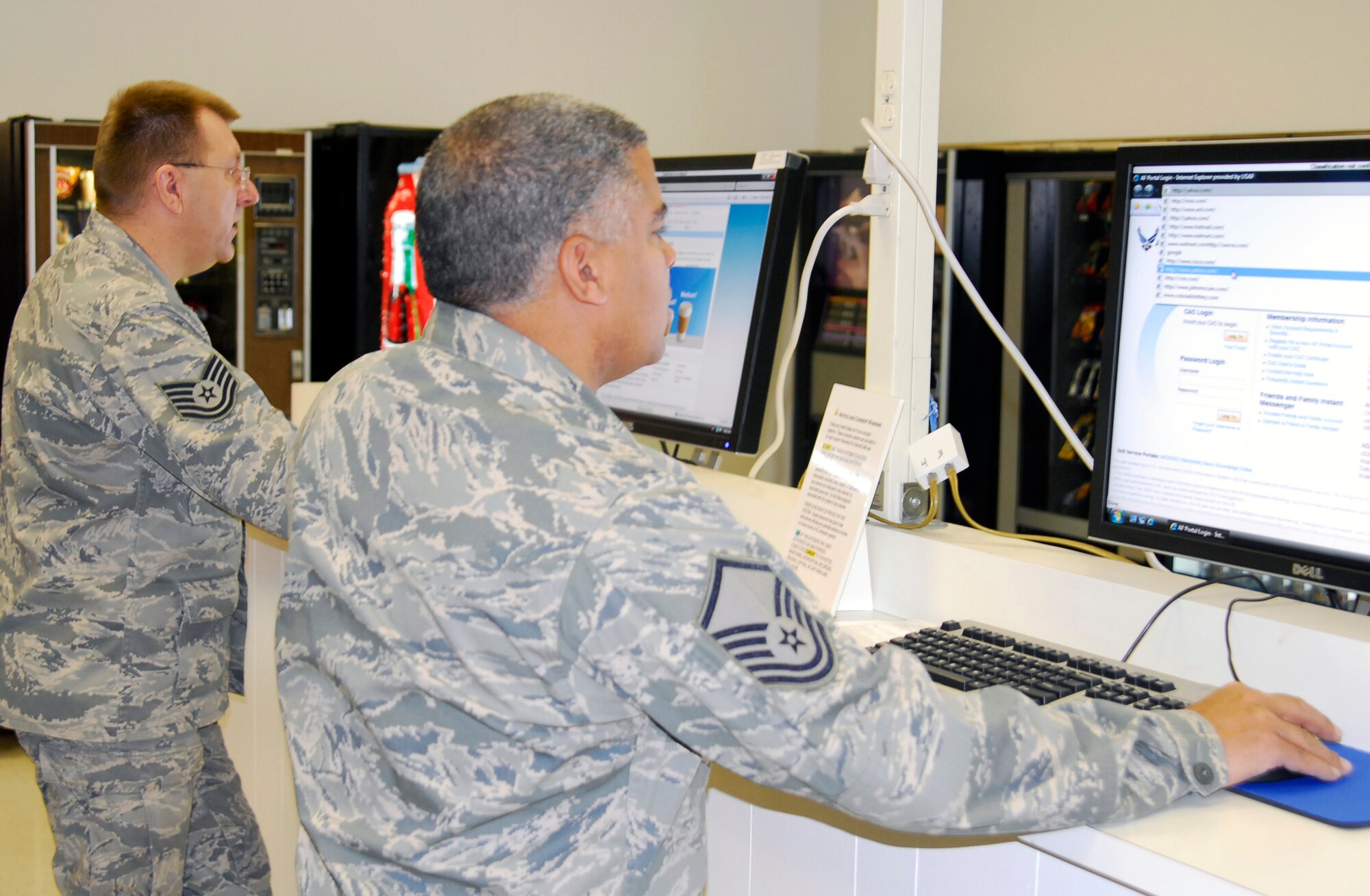 Master Sgt. Andrew Hunt, DPS, (foreground) and Tech. Sgt. Paul Kiepert, DPP, try out computers in the new internet cafe. The cafe computers are not connected to the government network, which allows users to check personal e-mail accounts or other sites that are restricted by work computers. (U.S. Air Force photo/Dwayne Beuthel)