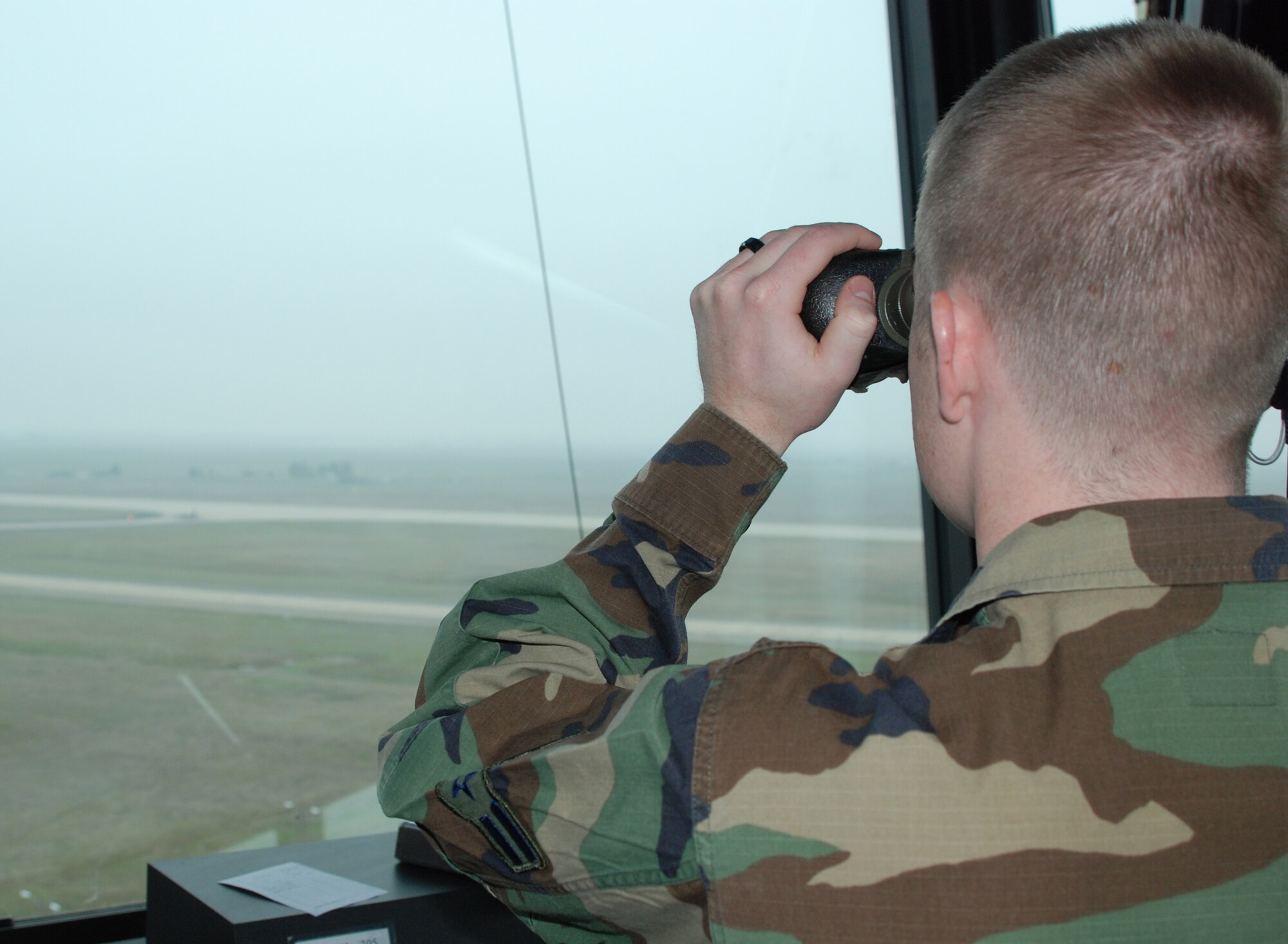 A member of the 9th Operations Support Squadron's Airfield Management Flight peers through the fog Jan. 7 at the control tower. Air traffic controllers communicate with pilots while they fly within a five-mile radius of Beale. (Photo by Airman 1st Class Chuck Broadway)