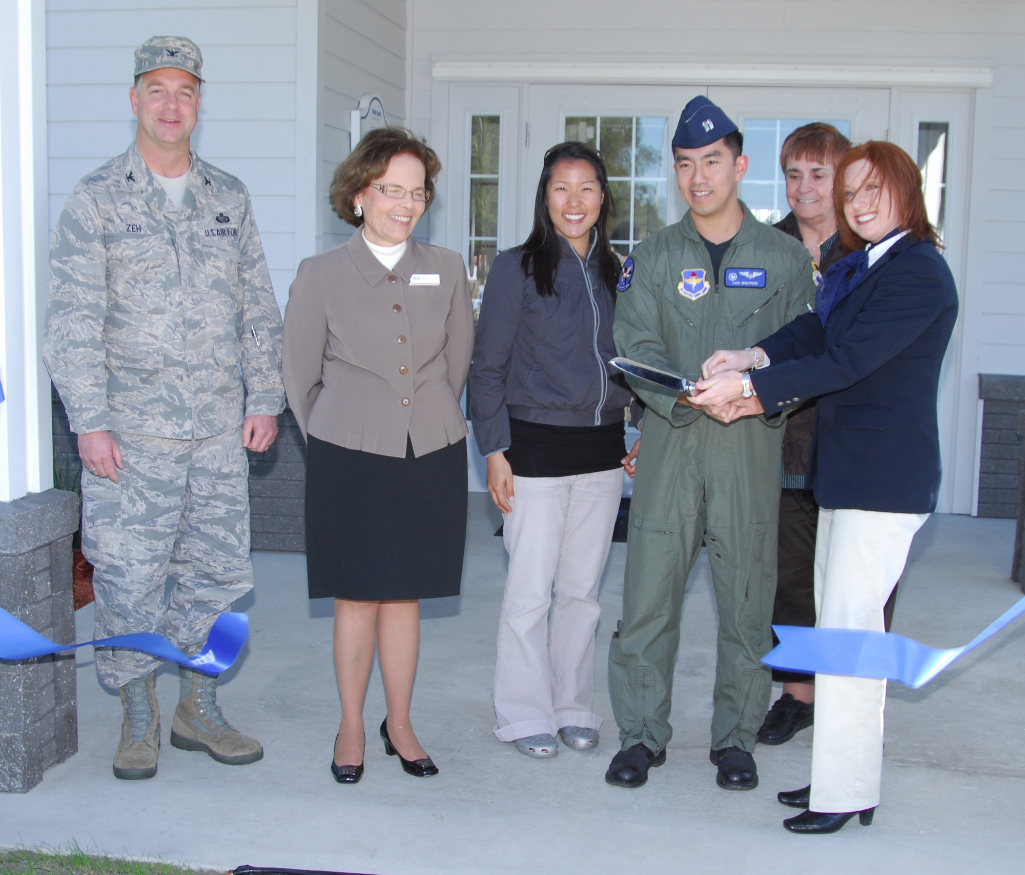 Col. David Zeh, 325th Mission Support Group commander, along with Terri Edelman, Balfour Beatty Communities Senior Vice President, Capt. Loc Nguyen and wife Lilly Nguyen, base residents, Mary Ann Barbieri, government housing management specialist, and Teri Henry, BBC manager, cut the ribbon to the brand new community center in Wood Manor housing Wednesday.  (U.S. Air Force photo by Lisa Norman)