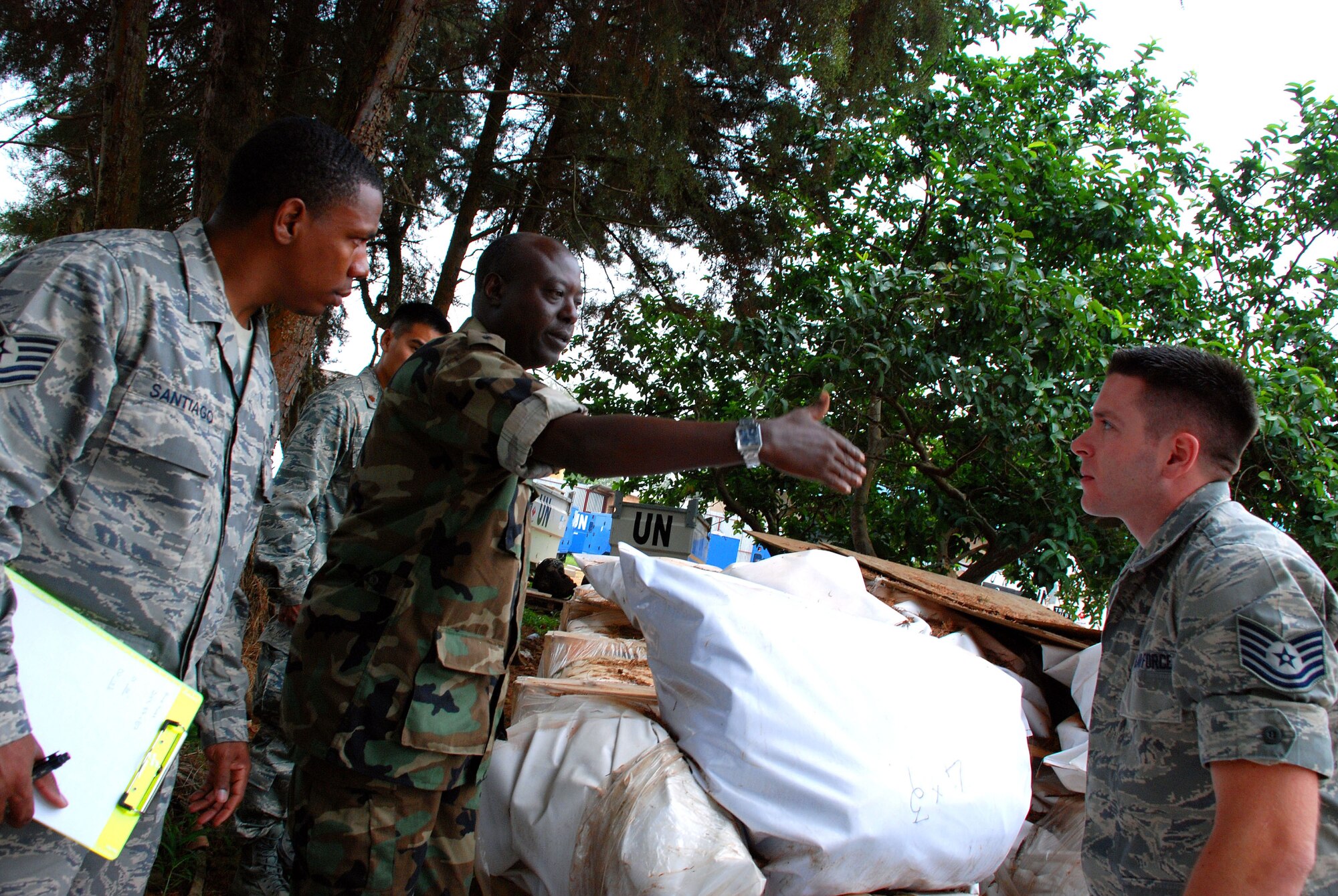 KIGALI, Rwanda-Tech. Sgts.  Cairo Santiago (left) and Bradley Ferda, 722nd Expeditionary Air Base Squadron, 17th Air Force, U.S. Africa Command, and Rwanda Defense Forces Captain Claude Karihunga inspect supplies and heavy equipment in support of United Nations African Mission in Darfur (UNAMID) airlift to Darfur region, Sudan, Jan. 07,2009. (Photo by Staff Sergeant Samuel Bendet) 