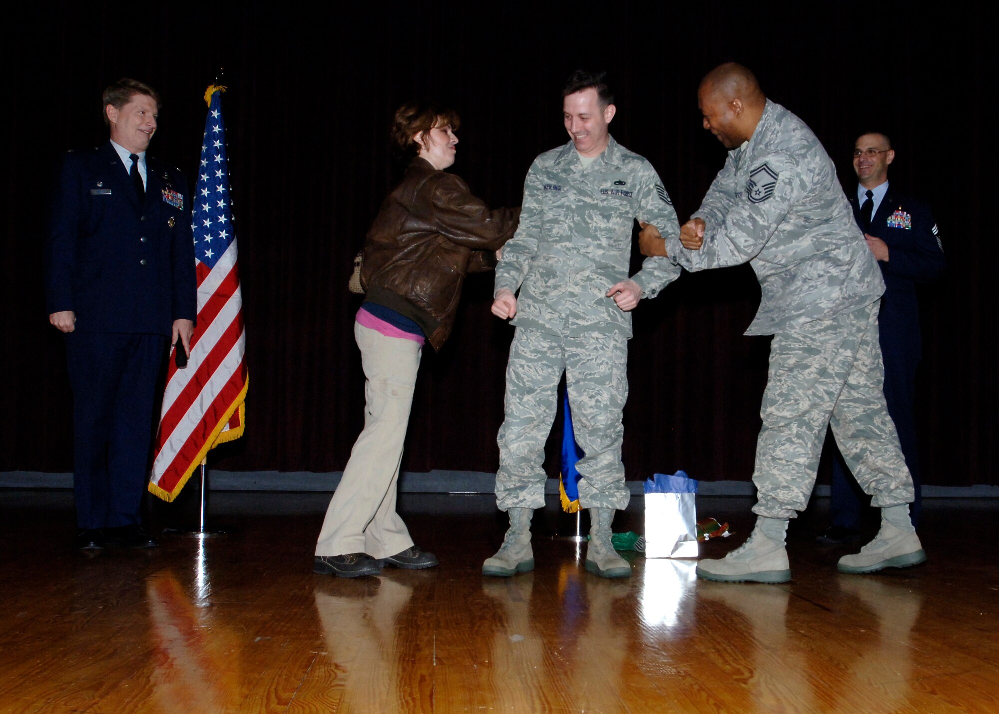 FAIRCHILD AIR FORCE BASE, Wash. – Master Sgt. Lance Dreiling, 92nd Operations Support Squadron commander’s executive, has master sergeant stripes pinned on by his wife, Toby, and Senior Master Sgt. Wesley Mathias, 92nd Operations Support Squadron Weather superintendant, during a surprise STEP promotion at the base promotion ceremony Dec. 31. Sergeant Dreiling was led to believe that he was the winner of a raffle drawing at the end of the promotion ceremony and was very surprised to see master-sergeant stripes inside his prize. (U.S. Air Force photo / Airman 1st Class Melissa L. Barnett)