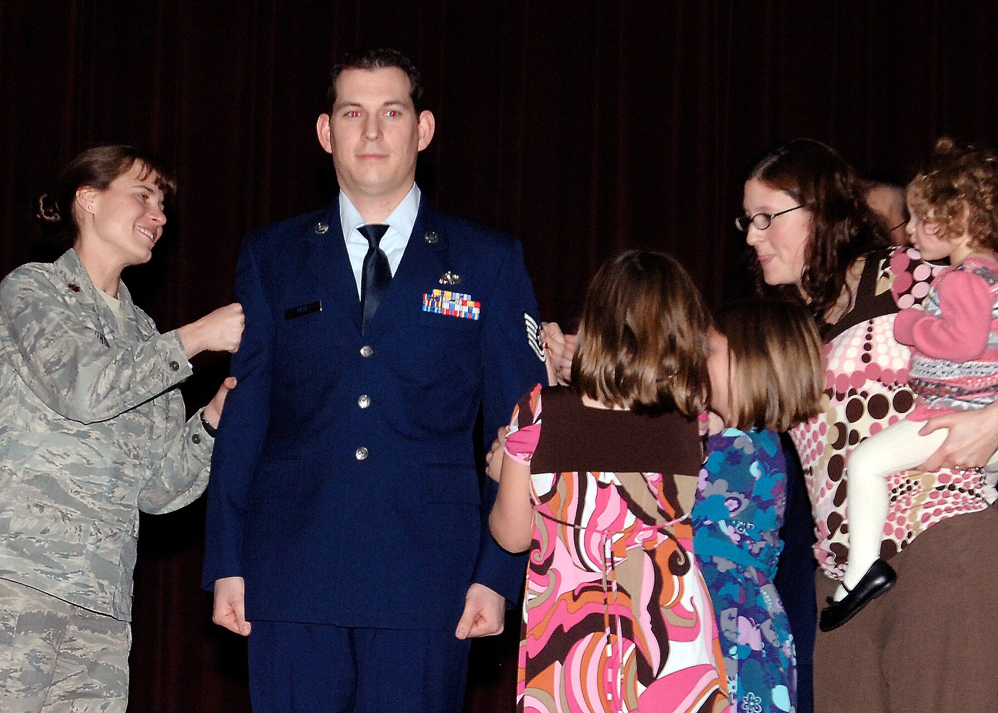 FAIRCHILD AIR FORCE BASE, Wash. – Tech. Sgt. Toby Pete, 92nd Communications Squadron quality assurance evaluator, receives his promotion punches from Major Melissa Cunningham, 92nd CS commander, his wife, Tracy, and daughters, Allisa Roberts, Tea Roberts and Penellope Pete, during the promotion ceremony at the base theater Dec. 31. (U.S. Air Force photo / Airman 1st Class Melissa Barnett)