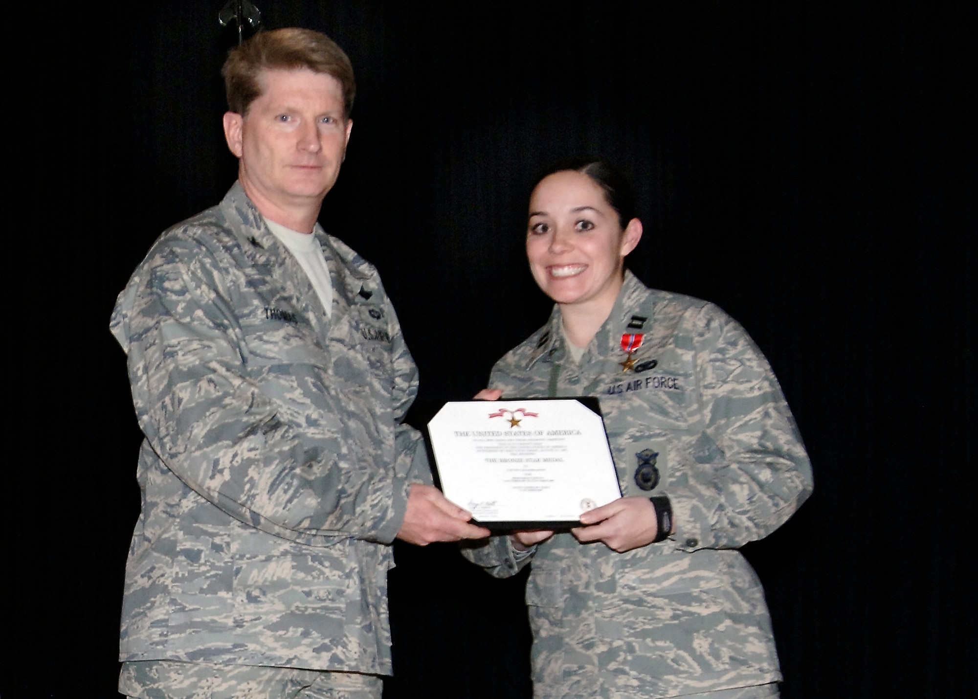 FAIRCHILD AIR FORCE BASE, Wash. – Capt. Cassandra Bates, 92nd Security Forces Squadron, and Col. Robert Thomas, 92nd Air Refueling Wing commander, pose with a Bronze Star medal certificate signifying Captain Bates’ meritorious service while forward deployed to a combat environment. The captain received the medal for her service in Iraq from October 2007 – October 2008, where she was the Flight Commander for the 732nd Expeditionary Security Forces Squadron. (U.S. Air Force photo / Airman 1st Class Melissa Barnett)