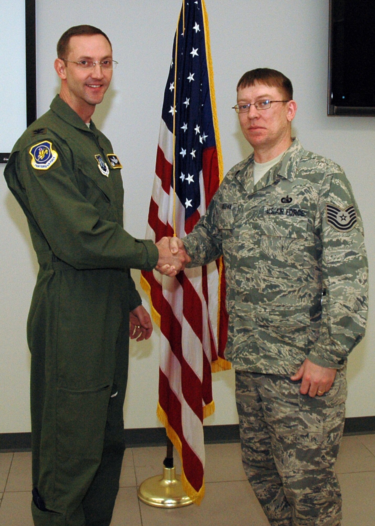 BUCKLEY AIR FORCE BASE, Colo. -- Tech. Sgt. Hal Sullivan, 460th Space Communications Squadron, is coined by Col. Wayne McGee, 460th Space Wing Commander, on Jan. 6 for being recognized as a distinguished graduate from the Forrest L. Vosler Non-Commissioned Officer Academy, Peterson Air Force Base, Colo., Dec. 18. (U.S. Air Force photo by Senior Airman Christopher Bush) 