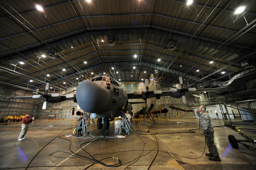 Staff Sgt. Corey Fisher, 15th Aircraft Maintenance Unit crew chief, monitors the lifting of an MC-130H Talon II from the 15th Special Operations Squadron using four jacks, Jan. 7. Sgt. Fisher receives feedback from all four personnel manning the jacks to ensure the aircraft is lifted evenly.  The jacks are pumped with hydraulic fluid forcing the jacks to extend, in turn lifting the aircraft to the desired height. (U.S. Air Force photo/Senior Airman Julianne Showalter)