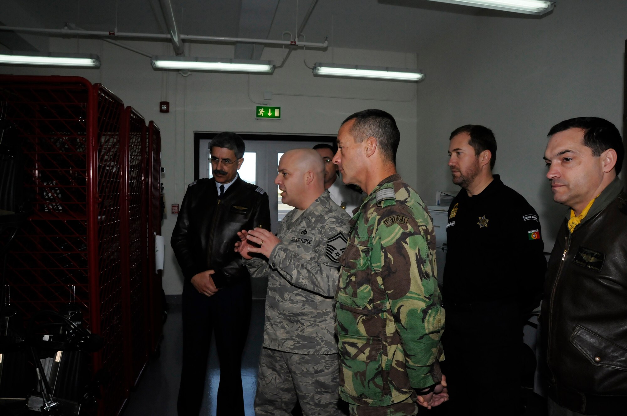 Senior Master Sgt. Keith Jimmo, 65th Civil Engineer Squadron, explains how the firefighters at Lajes Field service the self contained breathing apparatus bottles they use to breath air in Fire Fighting Operations to Col. Leonardo Oliveira, Head Quarters Azorean Air Zone chief of staff; Col. Luis Ruivo, Air Base Number 4 commander; Col. Jose Abracos, RG1 commander; and CDR. Joao Goncalves, Port Captain for Angra and Praia, during part of a tour of Lajes Field. The group was taken to see a wide range of operations done here, from the 65th Medical Group where they got to see how a U.S. Air Force medical team works and how it partners with the local community, to the 65th Operations Support Squadron, where they could see how flight operations are handled and how the base works with the Portuguese air force as well as civilian aviation. (U.S. Air Force photo by Guido Melo)  