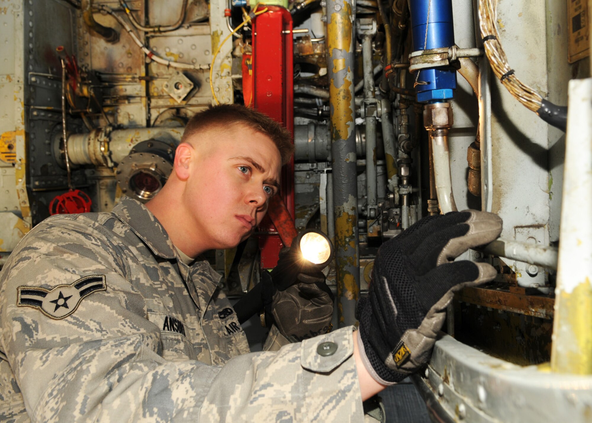 Airman 1st Class Brandon Ansbro, a crew chief from the 100th Aircraft Maintenance Squadron, performs a “Thru Flight Inspection” in the right wheel well of a KC-135 aircraft Jan. 6, 2009, at RAF Mildenhall, England. The purpose of the inspection is to identify any possible damage the aircraft might of received during flight operations and also to provide servicing when required. (U.S. Air Force photo by Staff Sgt. Jerry Fleshman)