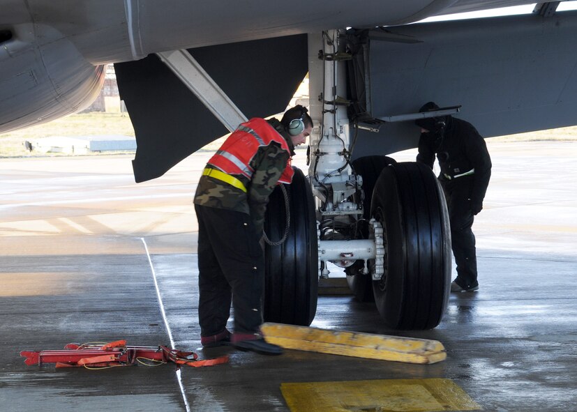Airman 1st Class Justin Drouin and Tech. Sgt. Erik Rayner, both 100th Aircraft Maintenance Squadron aircraft hydraulics system technicians, chock tires of a KC-135 aircraft during recovery procedures Jan. 6, 2009, in RAF Mildenhall, England. The chocks are installed to prevent the aircraft from rolling during non-operational procedures. (U.S. Air Force photo by Staff Sgt. Jerry Fleshman)