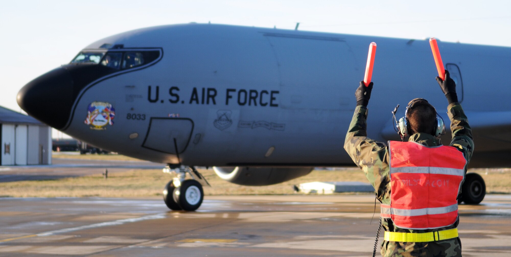 Airman 1st Class Justin Drouin, a 100th Aircraft Maintenance Squadron aircraft hydraulics system apprentice, marshals a KC-135 into its parking spot during recovery procedures Jan. 6, 2009, at RAF Mildenhall, England. Airman Drouin acts as the pilot’s eyes on the ground because of limited vision from inside the aircraft. (U.S. Air Force photo by Staff Sgt. Jerry Fleshman)