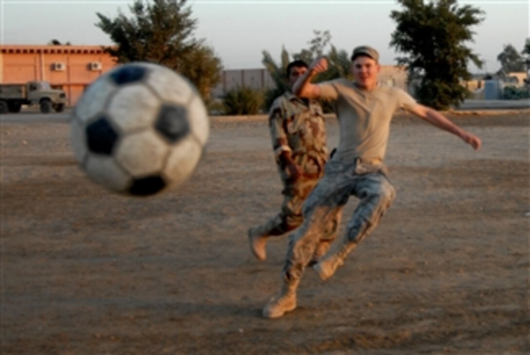 U.S. Army Pfc. Casey Wailes from the 1st Squadron, 10th Calvary Regiment, 2nd Brigade Combat Team, 4th Infantry Division clears the ball during a soccer game with Iraqi soldiers in Mahawil, Iraq, on Dec. 14, 2008.  