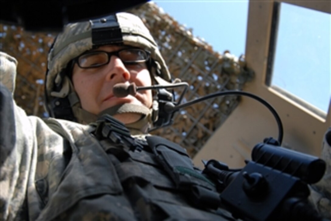 U.S. Army Spc. Chris Caldwell of Charlie Troop, 1st Squadron, 10th Calvary Regiment, 2nd Brigade Combat Team, 4th Infantry Division mans a gun turret while traveling in a convoy to Mahawil, Iraq, on Dec. 14, 2008.  