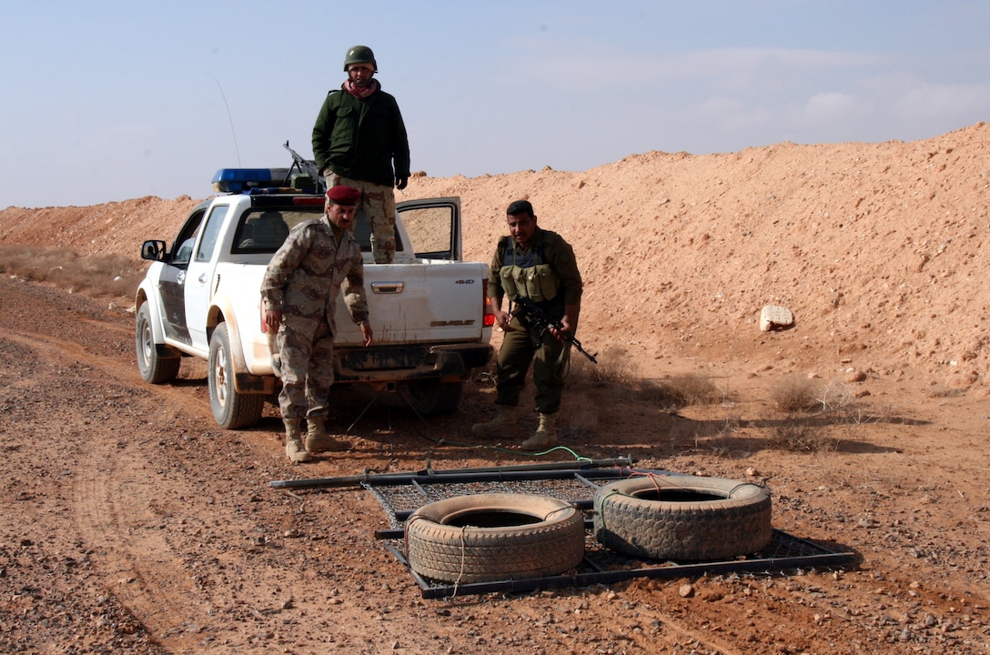Iraqi border patrolmen, the “Desert Wolves” of 2nd Battalion, 5th Iraqi Brigade, 2nd Region in al-Anbar Province, hook up a “drag” contraption to the back of their vehicle prior to a joint patrol with the Marines of 2nd Battalion, 25th Marine in the vicinity of the country’s border with Syria Jan. 10.  The Desert Wolves regularly drag the area near the border in order to identify and track anyone illegally crossing into Iraq.