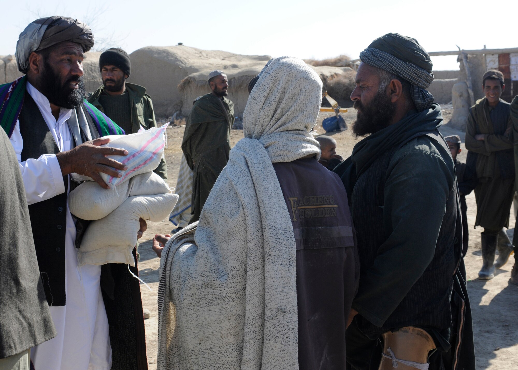 Noor Mohammed Akhwand, Waywand District Governor, distributes food to the residents of Ata Mohammed Kartz Jan. 6. COB Terminator and the presence of Alpha Company in the area made it possible for the humanitarian aid and Afghan government officials to travel safely to the village. (U.S. Air Force Photo / Staff Sgt. Eric Donner)

