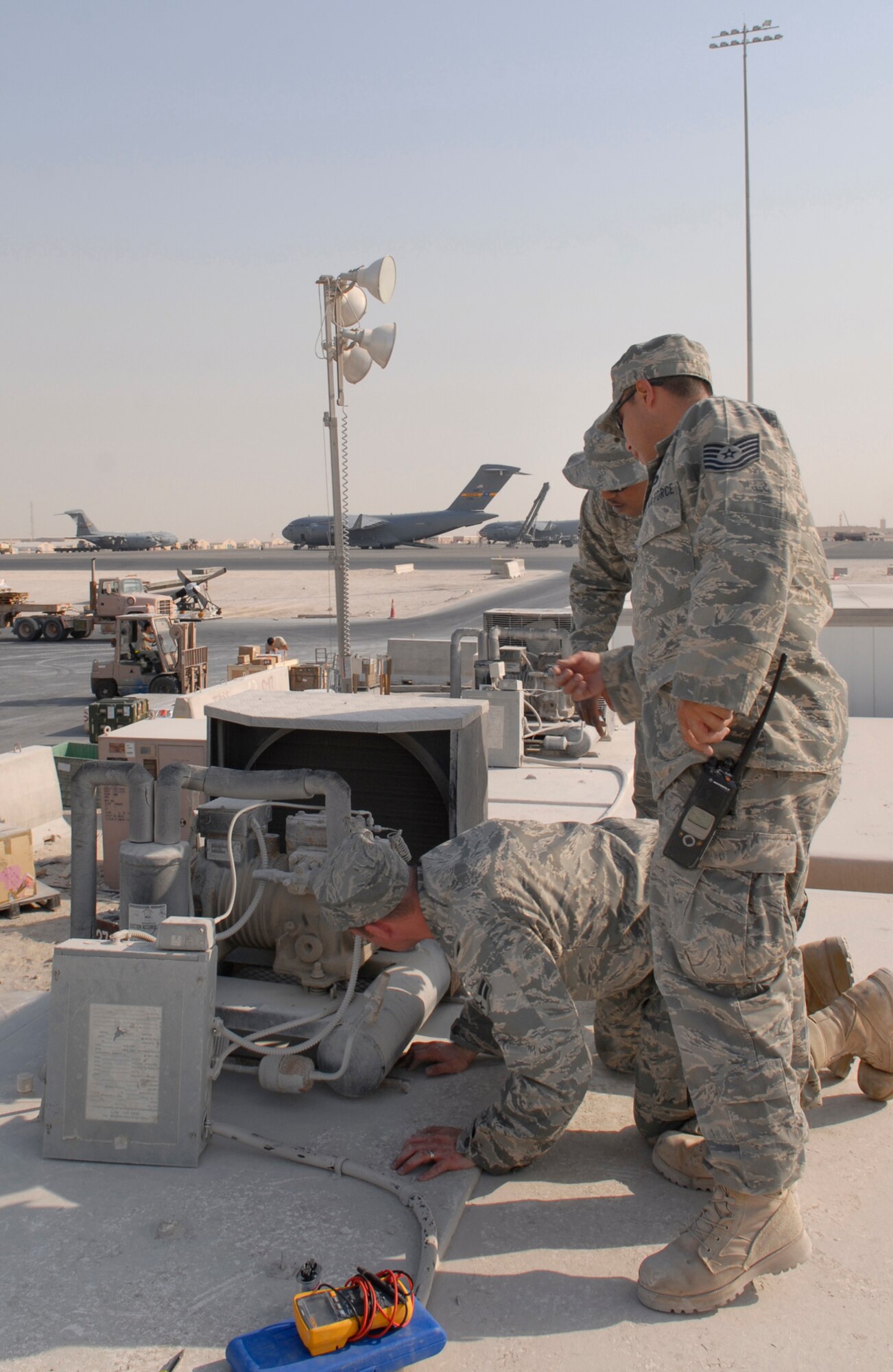 Tech. Sgt. Reno Cruz-Betancourt, HVAC/R Craftsman, Senior Airman Desmond Johnson, HVAC/R Journeyman, and Airman 1st Class James Turner, all assigned to the 379th Expeditionary Civil Engineering Squadron, replace a condensor fan motor for a medical refrigeration supply box Jan. 9, 2009 at an undisclosed location in Southwest Asia.  Tech. Sgt. Cruz-Betancourt hails from Los Angeles, California and is deployed from Travis Air Force Base, Calif.  Senior Airman Johnson hails from Mobile, Alabama and is also deployed from Travis Air Force Base, Calif.  Airman 1st Class Turner hails from College Station, Texas and is deployed from Beale Air Force Base, Calif.  All three are deployed in support of Operation Iraqi and Enduring Freedom and Joint Task Force-Horn of Africa. (U.S. Air Force photo/Airman 1st Class Andrew Satran)
