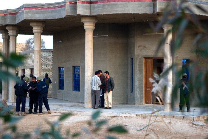 Iraqi Police speak with residents while conducting a weapons cache sweep in Lahib, with Marines from 2nd Platoon, Company W, Task Force 1st Battalion, 3rd Marine Regiment, Regimental Combat Team 1, January 10. During the IP coordinated cache sweep, Marines provided security while a search through a mosque uncovered hundreds of pounds of explosives, blasting caps, pressure switches, and detonation devices. (U.S. Marine Corps photo by Lance Cpl. Geoffrey T. Campbell/Released)