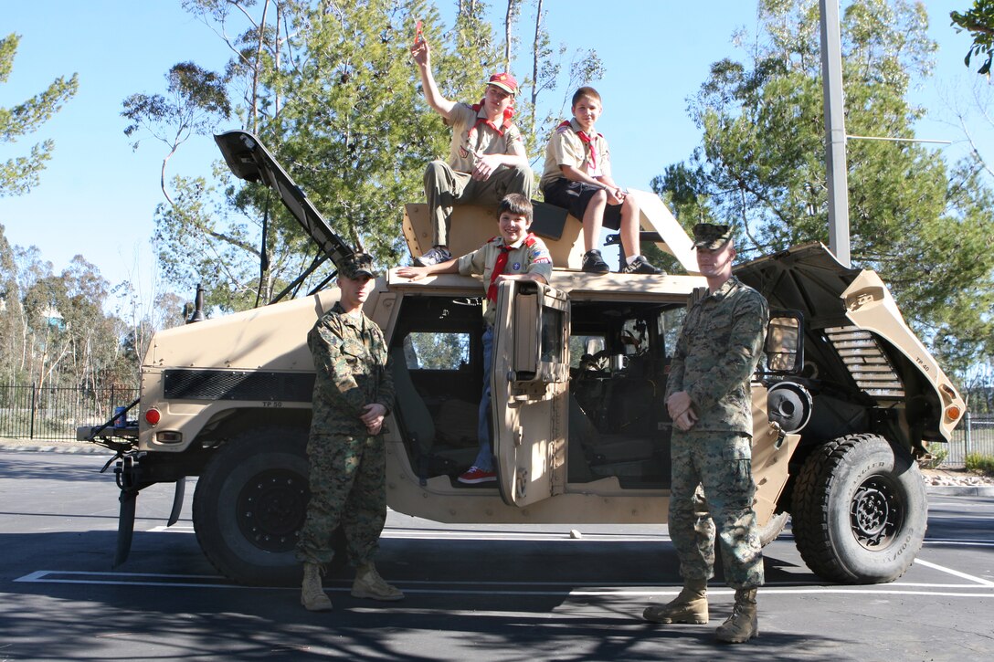 Cpl. Corbin L. Cassingham, a motor transportation operator for Marine Wing Support Squadron 373, Sgt. James R. Tilt, a motor transportation operator for MWSS-374, show Jake Wolzhauer, Codey Hughes and Parker Somes a humvee, Jan. 10. Both Marines answered many questions from curious scouts.