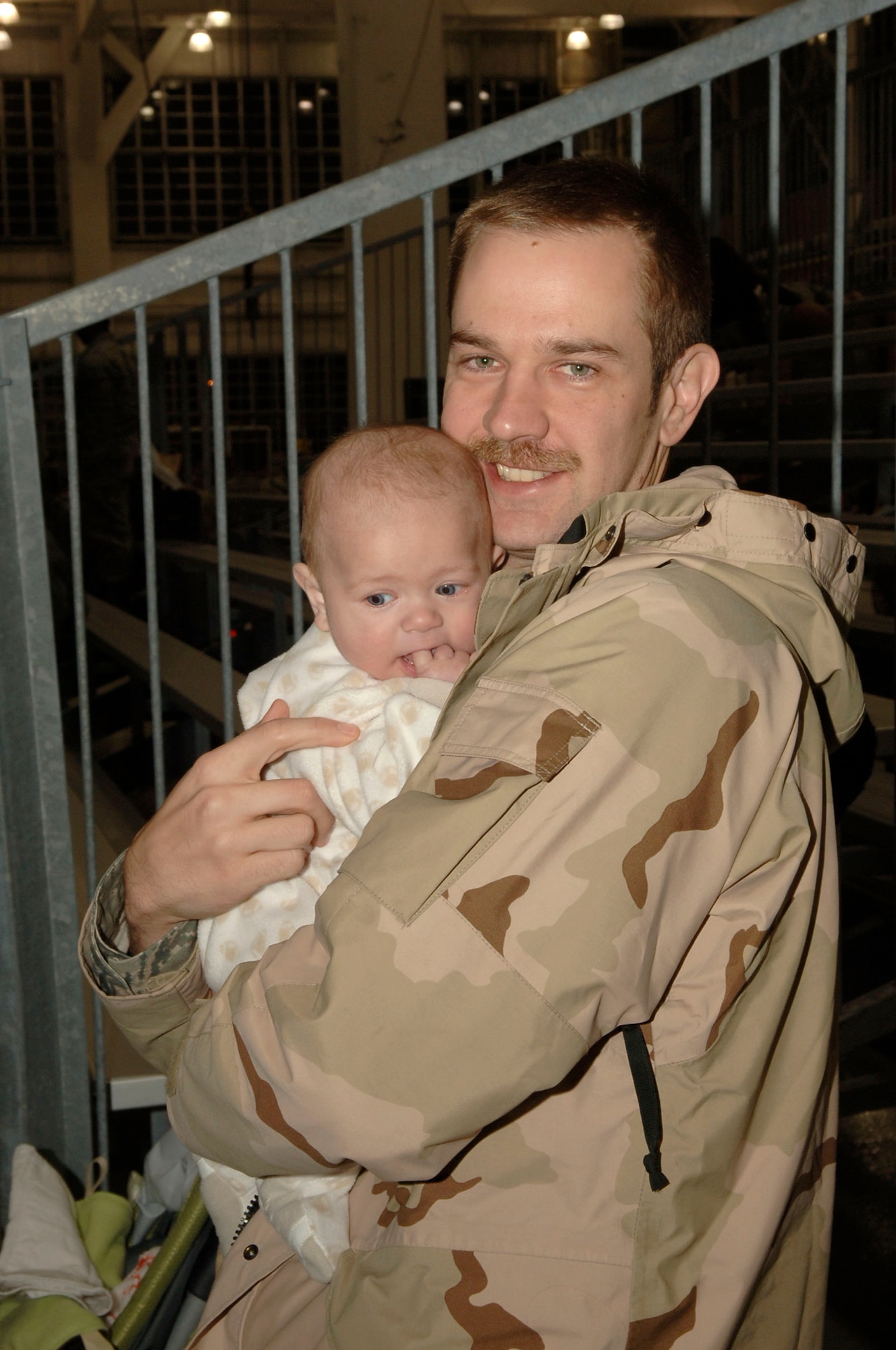 Just home from a deployment, an Airman sees his daughter for the first time at Operation Homecoming at Eglin Air Force Base Fla., Jan. 8.  Operation Homecoming invites family members and friends to greet their loved ones as soon as they return. (U.S. Air Force photo by Airman First Class Matt Loken)