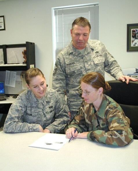 DOVER AIR FORCE BASE, Del. -- Senior Master Sgt. Michael DiLorenzo, 512th Airlift Wing senior recruiter, Staff Sgt. Jessica Hatch, 512th AW personnel employment chief and Airman Basic Ashley Eason, 512th AW personnel employment assistant, review the new awards available to Air Force reservists who participate in the Get 1 Now program. The program has recently been revamped to include awards like satellite radios and laptop computers. (Photo by Senior Airman Andria J. Allmond)