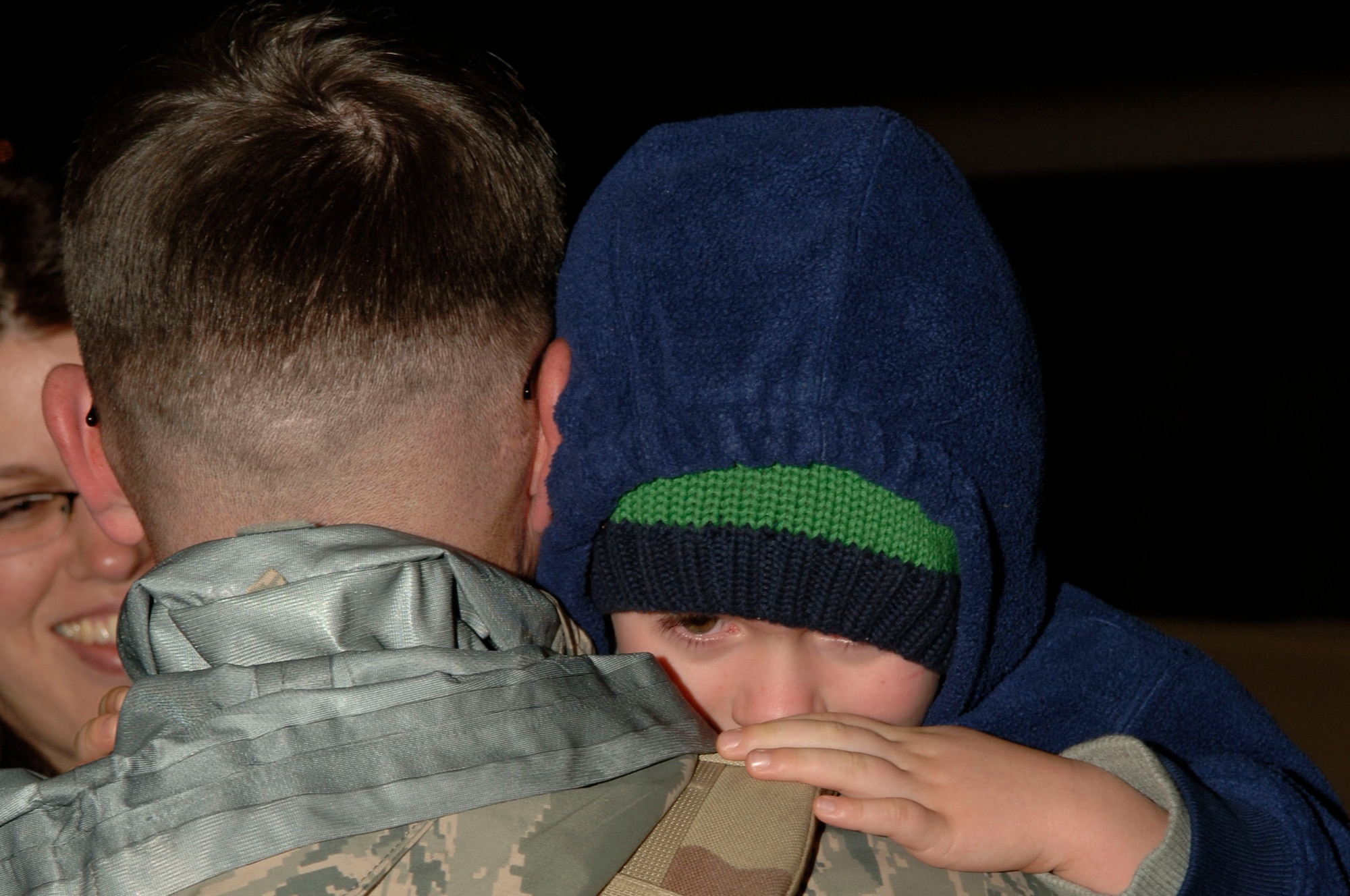 An Airman, just off the plane from a deployment, is reunited with his wife and son at Operations Homecoming at Eglin Air Force Base Jan. 8.  Operation Homecoming invites family members and friends to greet their loved ones as soon as they return.  (U.S. Air Force photo by Airman First Class Matt Loken)