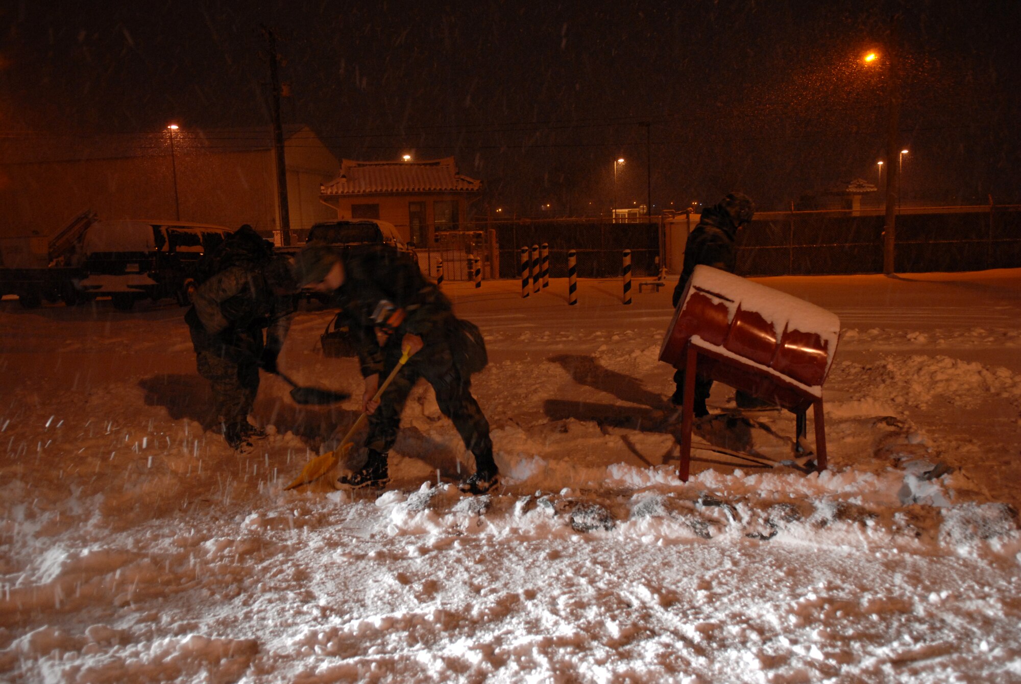 Airman 1st Class Christopher Neal,  Staff Sgt. Jeremiah waychoff and Staff Sgt. Gregory Stansel, 8th Logistics Readiness Squadron, clear snow around their building during the the Peninsula-Wide-Operational Readiness Exercise Beverly Bulldog 09-01 at Kunsan Air Base, Republic of Korea, Jan. 12, 2009. The PENORE will test the wolf pack on its wartime capabilities and response actions in preparation for an upcoming Operational Readiness Inspection. (U.S. Air Force Photo by Senior Airman Angela Ruiz)  
