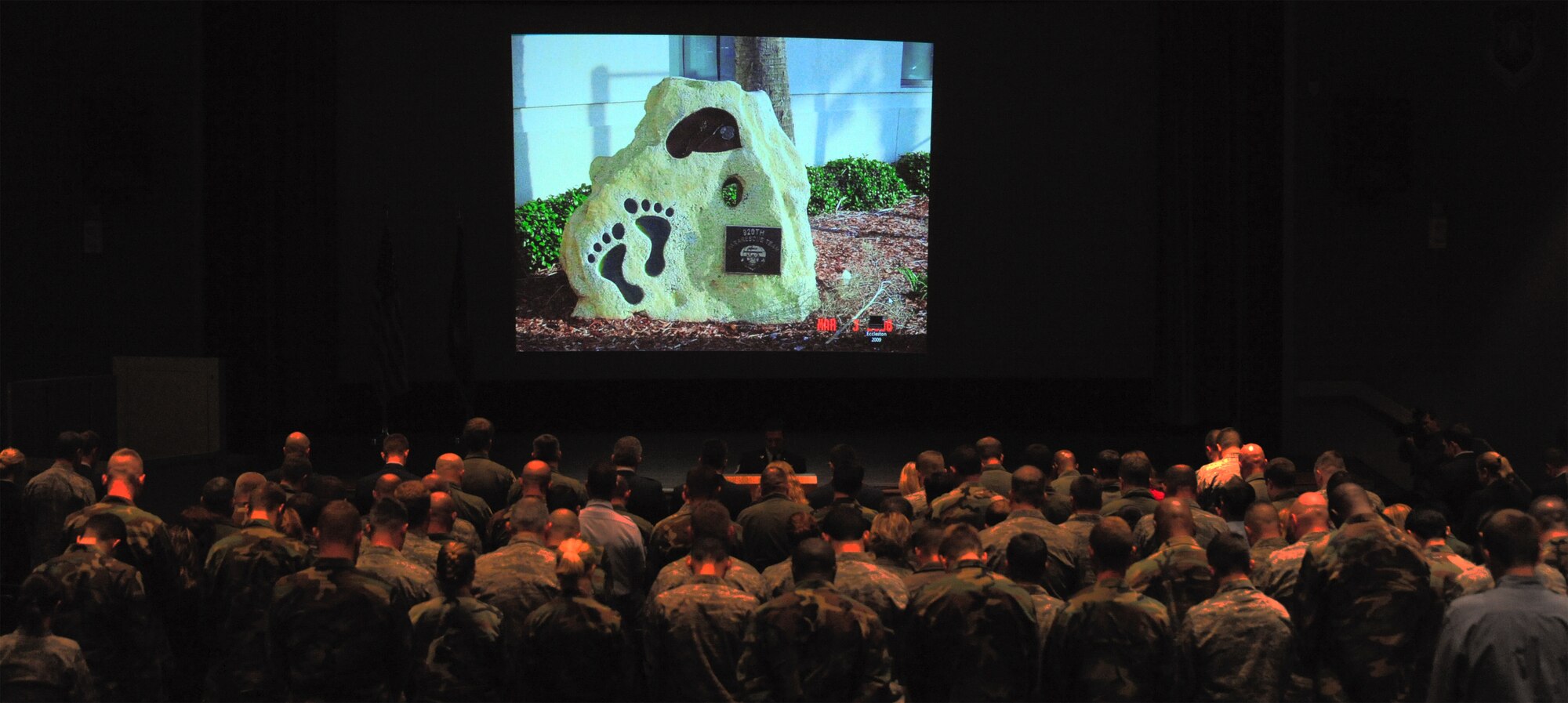 PATRICK AIR FORCE BASE, Fla. -- Members of the 920th Rescue Wing pause in prayer during a building-dedication ceremony held at the base theater here today. The wing's new parachute-rigging facility was renamed the Eccleston Pararescue Facility in honor of Staff Sgt. Douglas Eccleston, who was killed Dec. 7, 2001, during a rescue mission off Bermuda when his inflatable raft capsized while leaving the 600-foot supertanker Alam Belia, where he and a 920th Rescue Wing team treated a critically-ill crewman. He was the first 920th member to die during a rescue. (U.S. Air Force photo/Tech. Sgt. Paul Flipse)