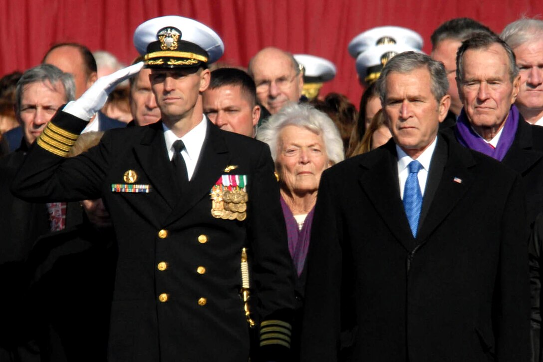 U.S. Navy Capt. Kevin E. O'Flaherty, left, commanding officer of the aircraft carrier USS George H.W. Bush, stands next to President George W. Bush during a 21-gun salute during the commissioning ceremony of the aircraft carrier USS George H.W. Bush at Naval Station Norfolk, Va. , Jan. 10, 2009. U.S. Navy photo by Petty Officer 3rd Class Micah P. Blechner