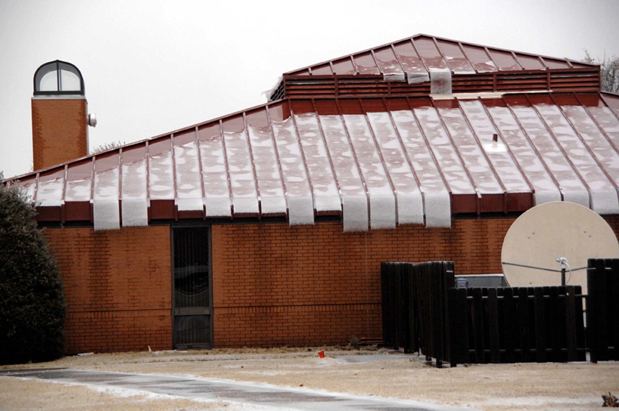 Sheets of ice hang from the roof and cover the walkway on base at Bldg.