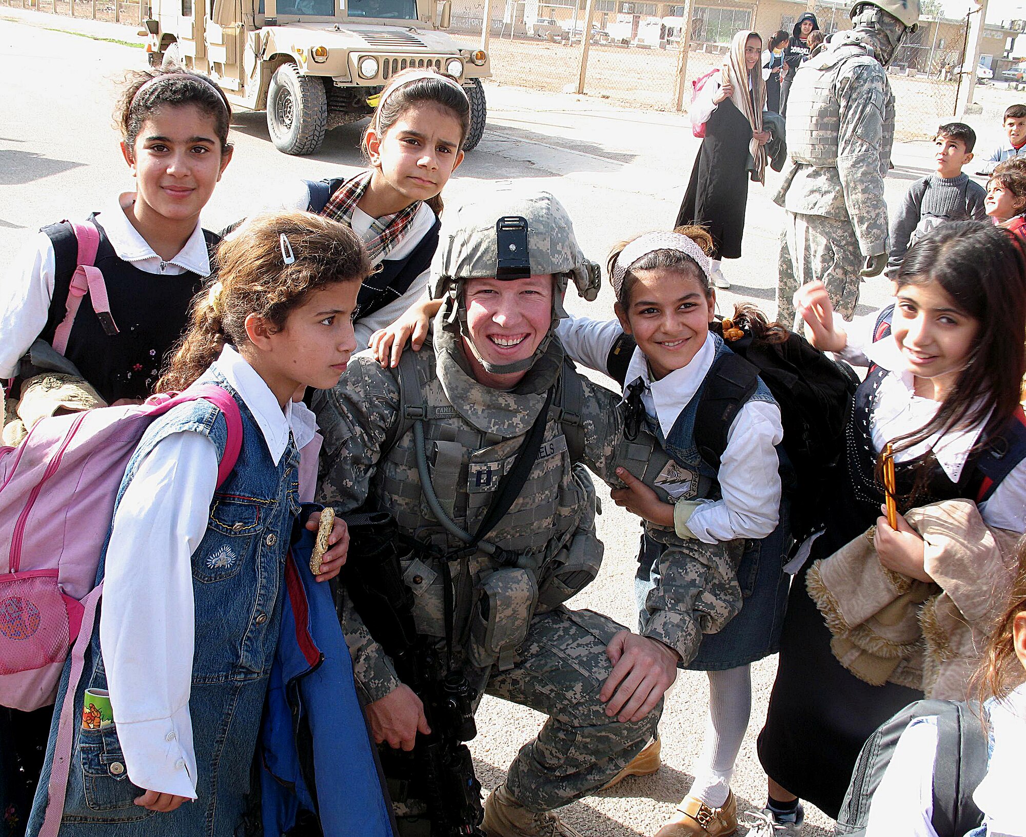 Capt.  Jason Daniels, 532nd Expeditionary Security Forces Squadron, enjoys a moment with Iraqi children at a local undisclosed village in the Middle East during a visit where humanitarian aid was provided and school supplies delivered. Captain Daniels is deployed from Eielson Air Force Base and is assigned to the 354th Security Forces Squadron. (Courtesy photo/Staff Sgt. Nicholas Rud, 532 ESFS)