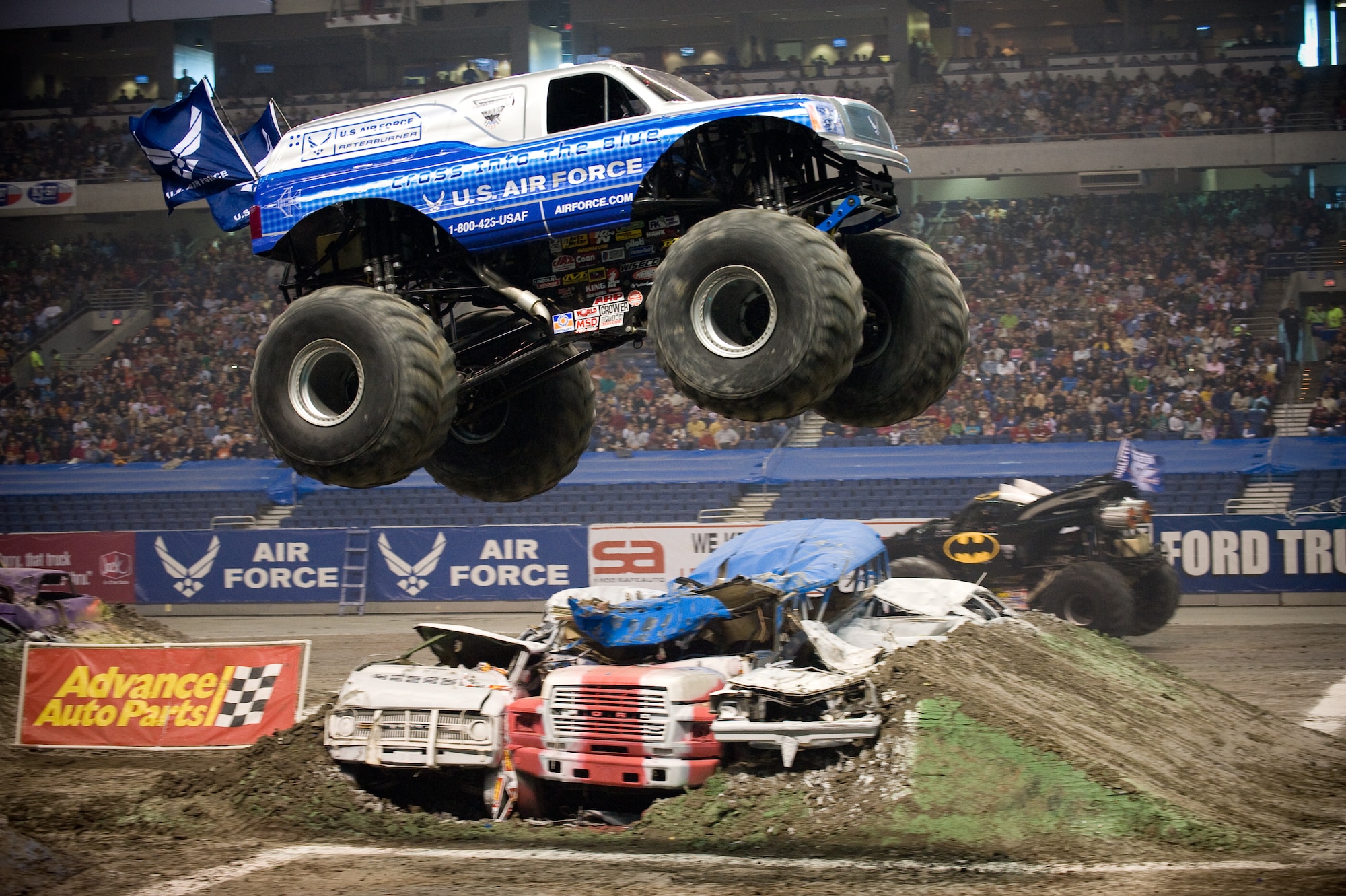 Damon Bradshaw, in the Air Force Afterburner monster truck, soars through the air Jan. 11 during the Monster Jam at the Alamodome in San Antonio.  Mr. Bradshaw took second with fast lap times and freestyle performances that had the crowd of approximately 45,000 up and cheering.  Afterburner's 540 cubic-inch Merlin supercharged racing V-8 engine churns out 1,425 horsepower.  Mr. Bradshaw, in his 3rd season, demonstrated that he had mastered the application of power by launching the 10,000-lb vehicle more than 40 feet in the air, thrilling the crowd. Afterburner is equipped with 66" tall, 750-lb wheels and tires and has four-wheel steering. Combine that with massive amounts of power and Mr. Bradshaw can make the truck spin on a dime by turning all four wheels and spinning out. (U.S. Air Force photo/Lance Cheung)