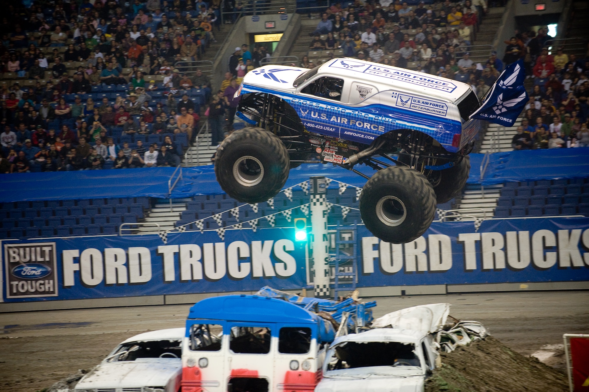 Damon Bradshaw, in the Air Force Afterburner monster truck, soars through the air Jan. 11 during the Monster Jam at the Alamodome in San Antonio.  Mr. Bradshaw took second with fast lap times and freestyle performances that had the crowd of approximately 45,000 up and cheering.  Afterburner's 540 cubic-inch Merlin supercharged racing V-8 engine churns out 1,425 horsepower.  Mr. Bradshaw, in his 3rd season, demonstrated that he had mastered the application of power by launching the 10,000-lb vehicle more than 40 feet in the air, thrilling the crowd. Afterburner is equipped with 66" tall, 750-lb wheels and tires and has four-wheel steering. Combine that with massive amounts of power and Mr. Bradshaw can make the truck spin on a dime by turning all four wheels and spinning out. (U.S. Air Force photo/Lance Cheung)