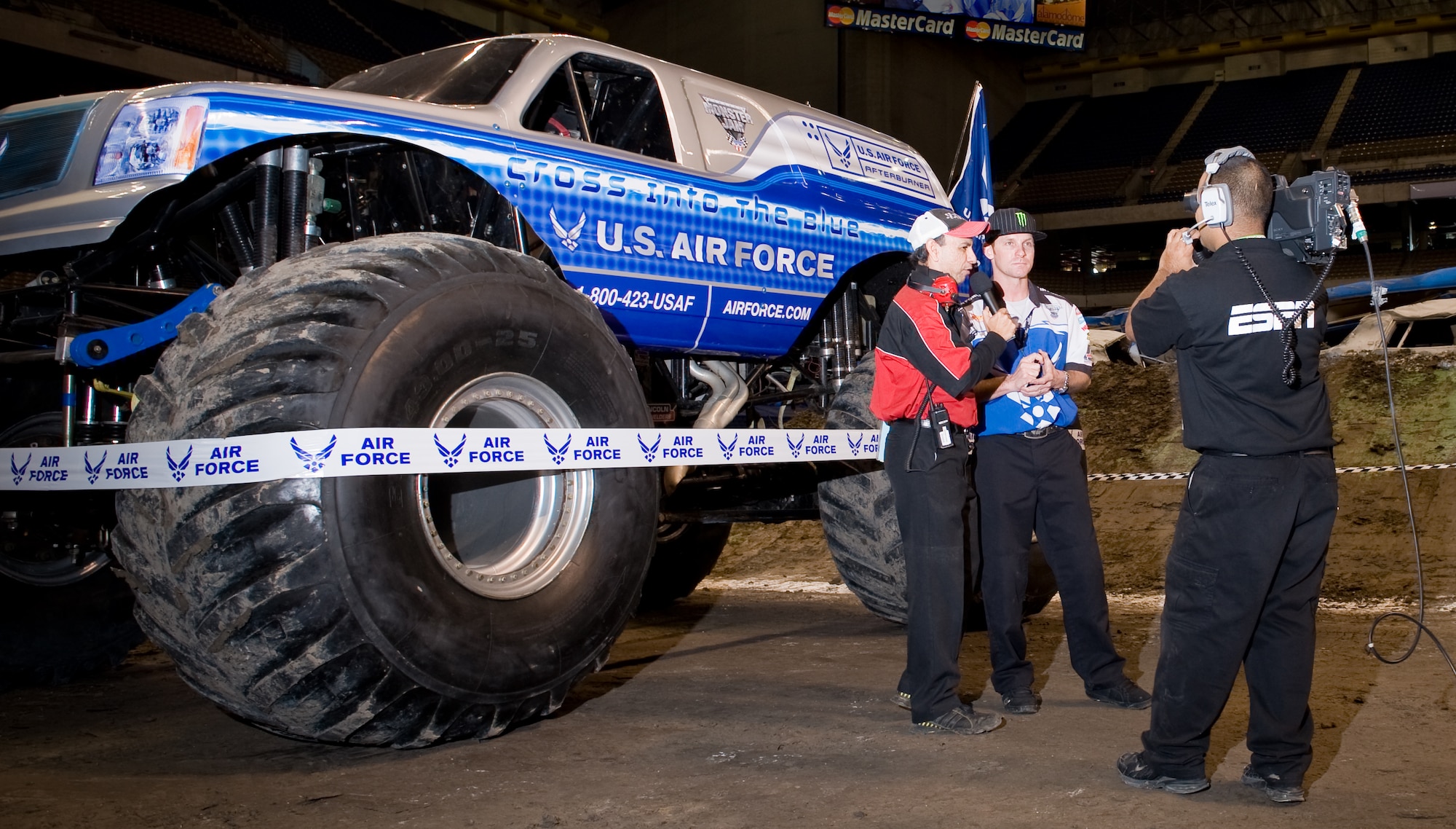 Air Force monster truck driver Damon Bradshaw is interviewed Jan. 11 during the 2009 Monster Jam at the Alamodome in San Antonio.  Driving Afterburner, Mr. Bradshaw took second with fast lap times and freestyle performances that had the crowd of approximately 45,000 up and cheering.  Afterburner's 540 cubic-inch Merlin supercharged racing V-8 engine churns out 1,425 horsepower.  Mr. Bradshaw, in his 3rd season, demonstrated that he had mastered the application of power by launching the 10,000-lb vehicle more than 40 feet in the air, thrilling the crowd. Afterburner is equipped with 66" tall, 750-lb wheels and tires and has four-wheel steering. Combine that with massive amounts of power and Mr. Bradshaw can make the truck spin on a dime by turning all four wheels and spinning out.  (U.S. Air Force photo/Lance Cheung)