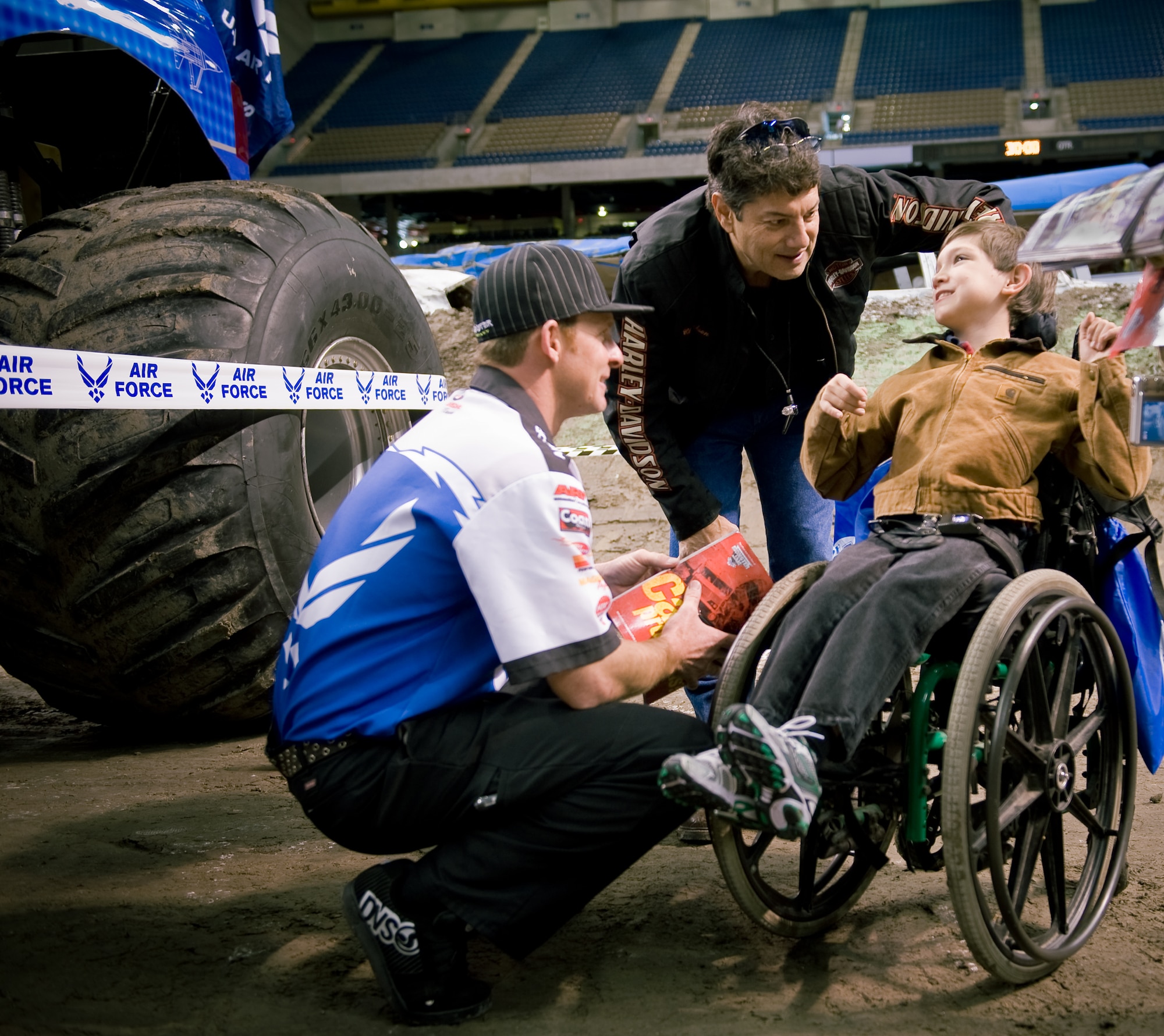 Air Force monster truck driver Damon Bradshaw (left) chats with Christopher Jackson Jr. and his father during a 2009 Monster Jam pre-competition event Jan. 11 at the Alamodome in San Antonio.  Later in the afternoon, 16 monster trucks, including Mr. Bradshaw driving Afterburner, competed head-to-head in a timed event and a freestyle event.  Mr. Bradshaw took second with fast lap times and freestyle performances that had the crowd of approximately 45,000 up and cheering.  Afterburner's 540 cubic-inch Merlin supercharged racing V-8 engine churns out 1,425 horsepower.  Mr. Bradshaw, in his 3rd season, demonstrated that he had mastered the application of power by launching the 10,000-lb vehicle more than 40 feet in the air, thrilling the crowd. Afterburner is equipped with 66" tall, 750-lb wheels and tires and has four-wheel steering. Combine that with massive amounts of power and Mr. Bradshaw can make the truck spin on a dime by turning all four wheels and spinning out.  (U.S. Air Force photo/Lance Cheung)