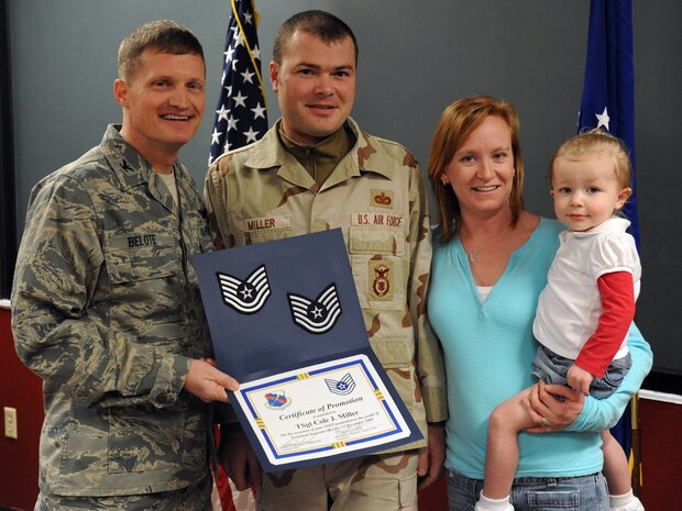 Staff Sgt. Cole Miller, 99th Ground Combat Training Squadron’s combat arms instructor, joined by his wife Carissa and daughter Madison, 2, receives his Technical Sergeant STEP promotion stripes from Col. Dave Belote, the 99th Air Base Wing Commander Dec. 23. (courtesy photo)